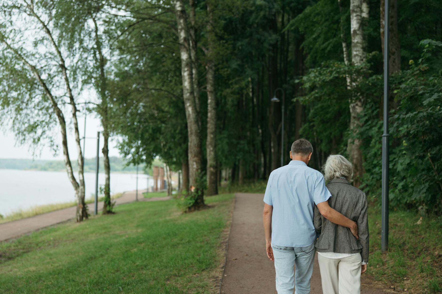 A senior couple enjoying a gentle walk in a park as part of post-angioplasty recovery