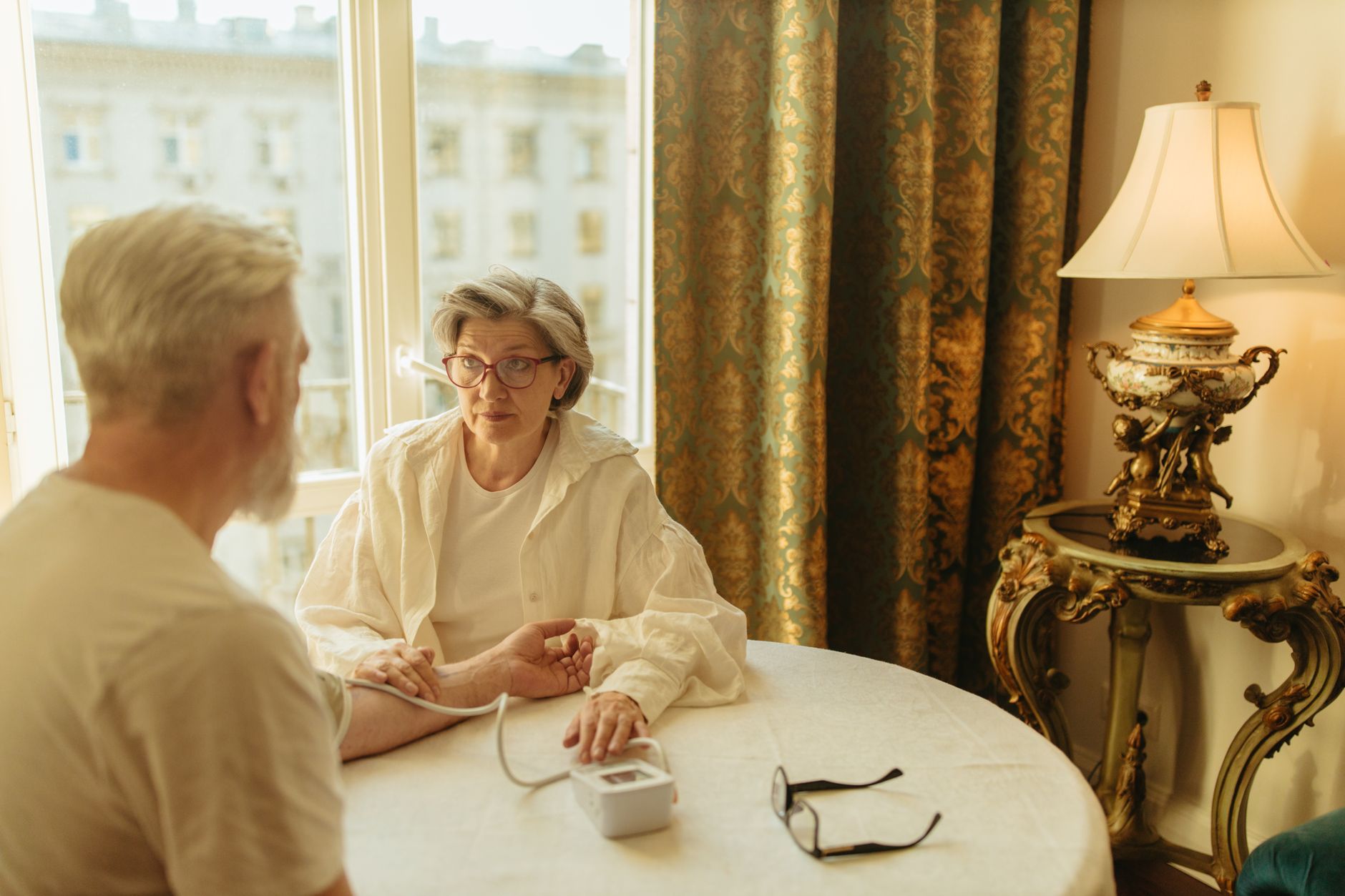 A doctor checking an older patient's blood pressure as part of cardiovascular risk assessment