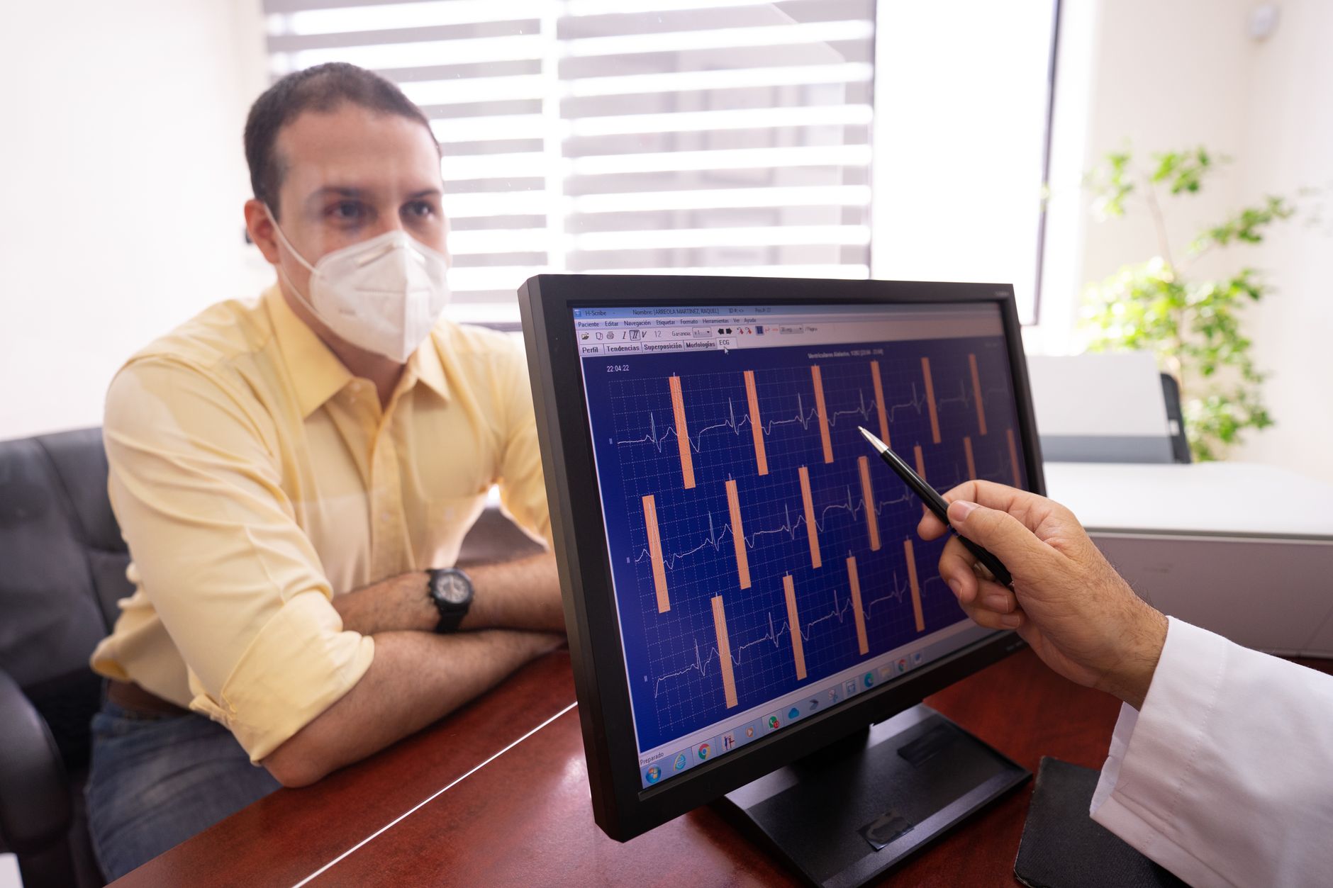 An interventional cardiologist reviewing heart imaging scans in a catheterisation lab