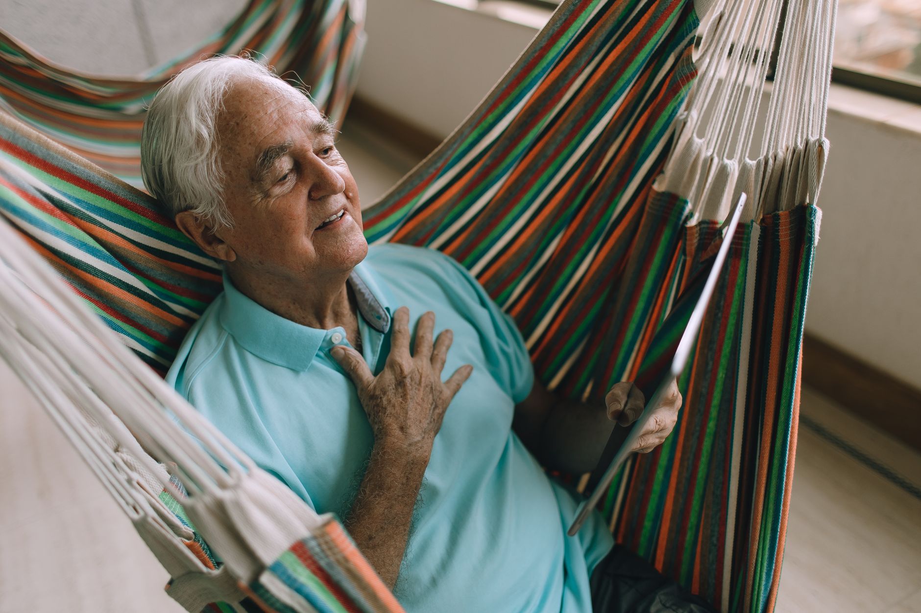 An older man placing his hand on his chest, noticing an irregular heartbeat