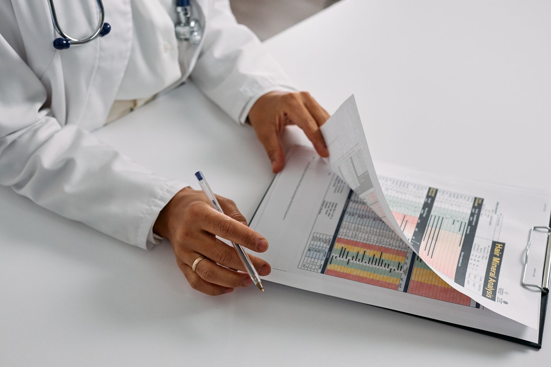 A cardiologist reviewing a patient's medication chart and recovery plan at a follow-up appointment