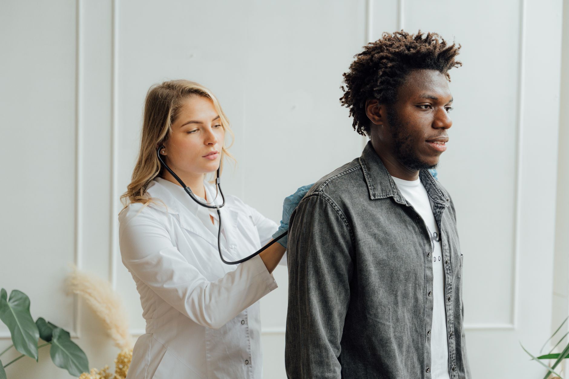 Cardiologist listening to a patient's heartbeat with a stethoscope during a consultation