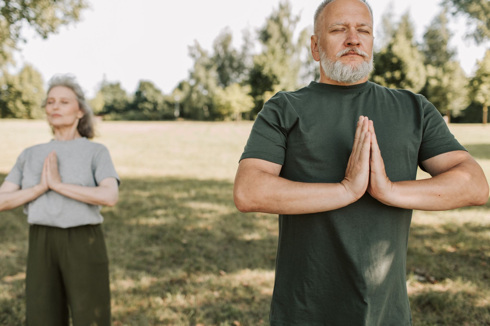 Senior woman practising meditation outdoors to manage emotional stress for heart health