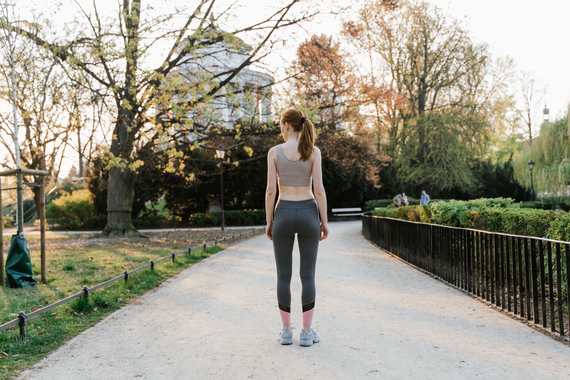A person enjoying a gentle morning walk in a park, representing active but mindful living with a managed heart condition