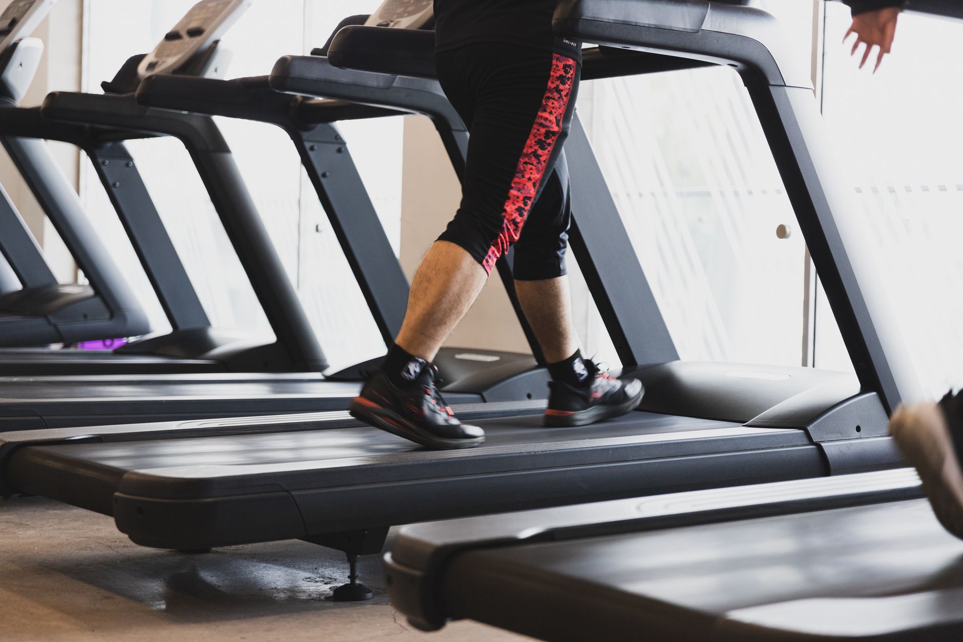 A patient walking on a treadmill during a supervised cardiac rehabilitation exercise session