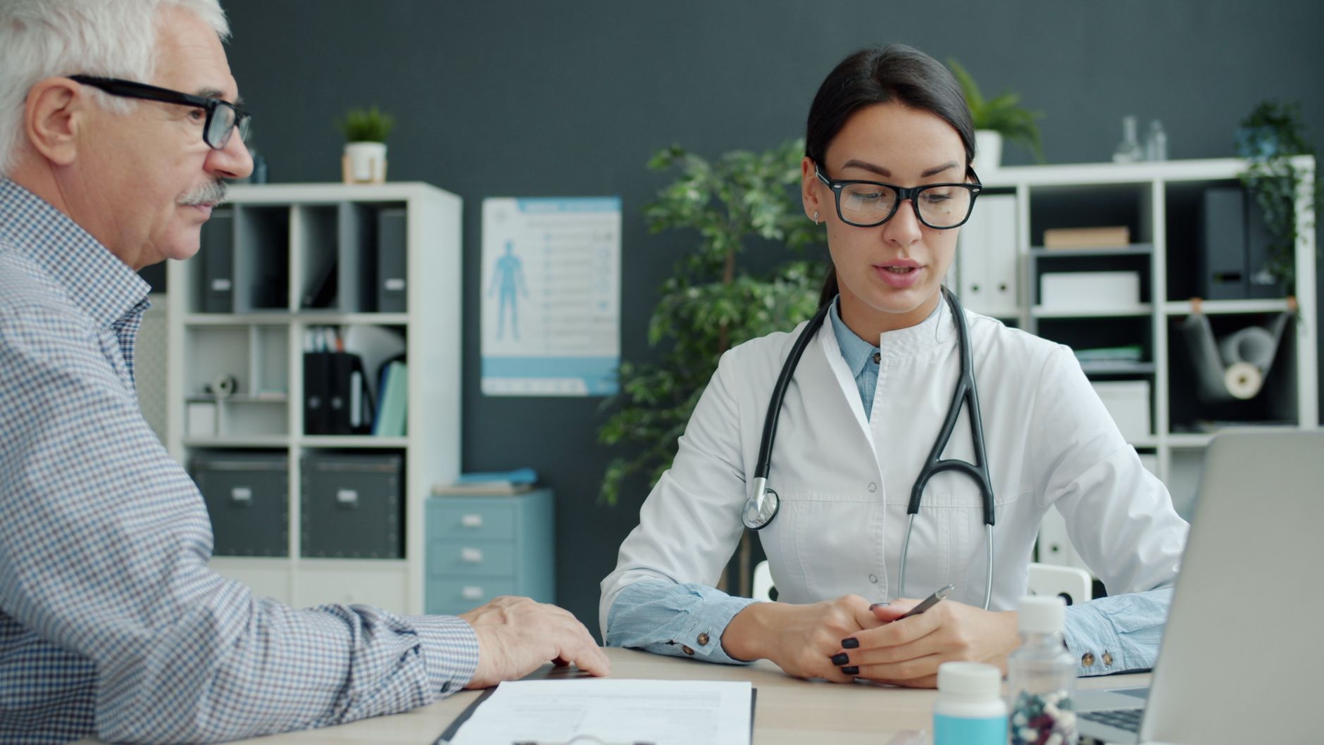 A senior patient discussing their cardiac test results with a doctor at a clinic