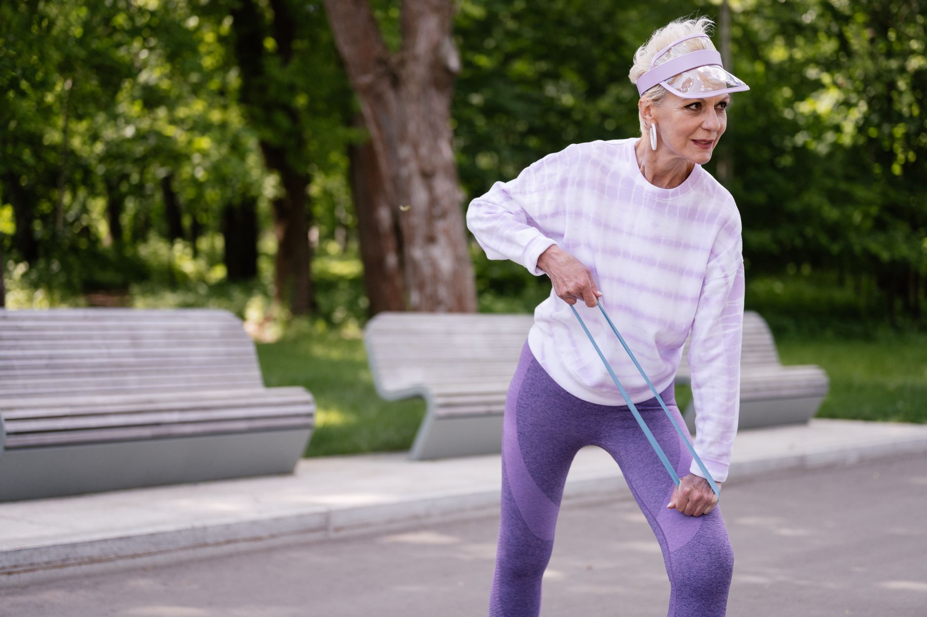 An older woman jogging in a park, staying active for heart health
