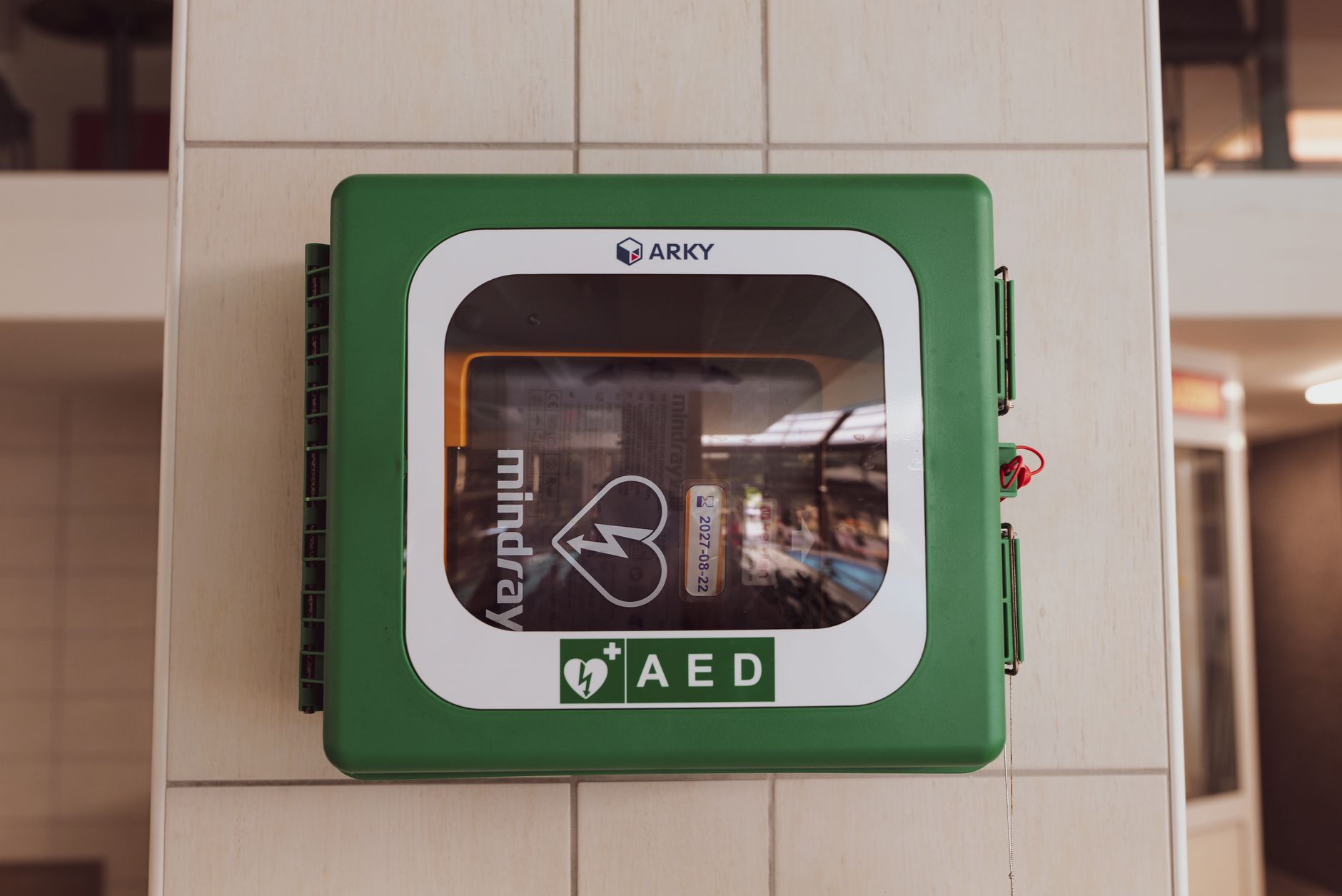 Automated External Defibrillator (AED) mounted on a wall in a public sports facility