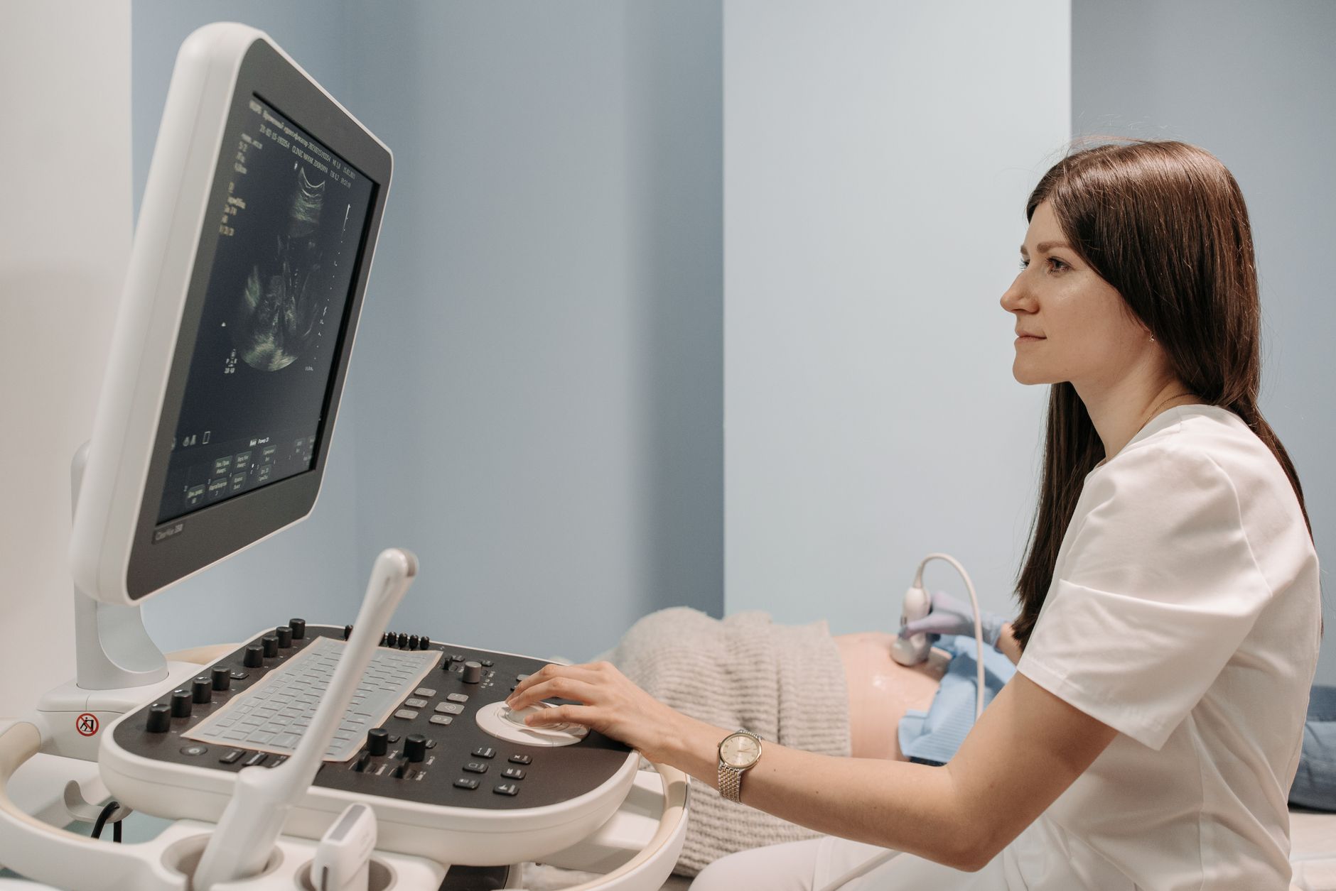 A cardiologist performing a comfortable echocardiogram (heart ultrasound) on a young child with a parent present