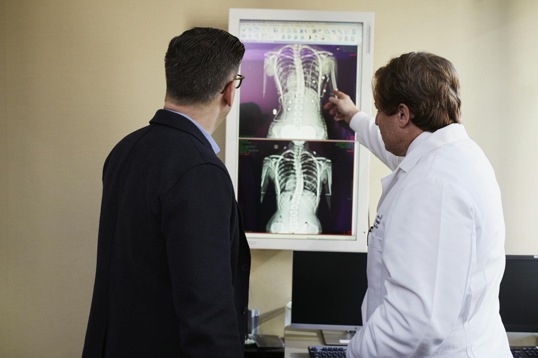 A cardiologist explaining a cardiac procedure to a patient in a consultation room