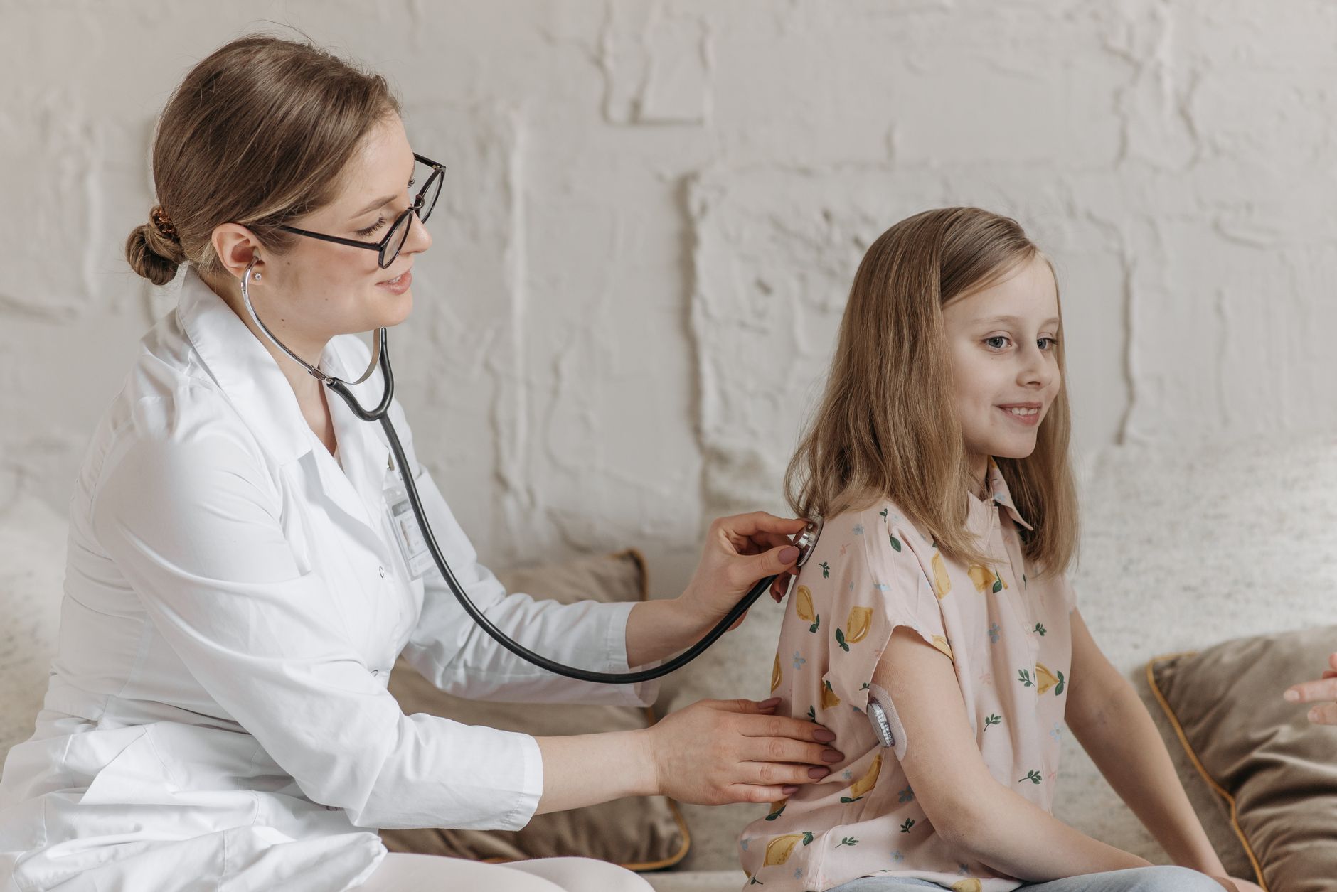 A cardiologist listening to a patient's heart with a stethoscope during a checkup