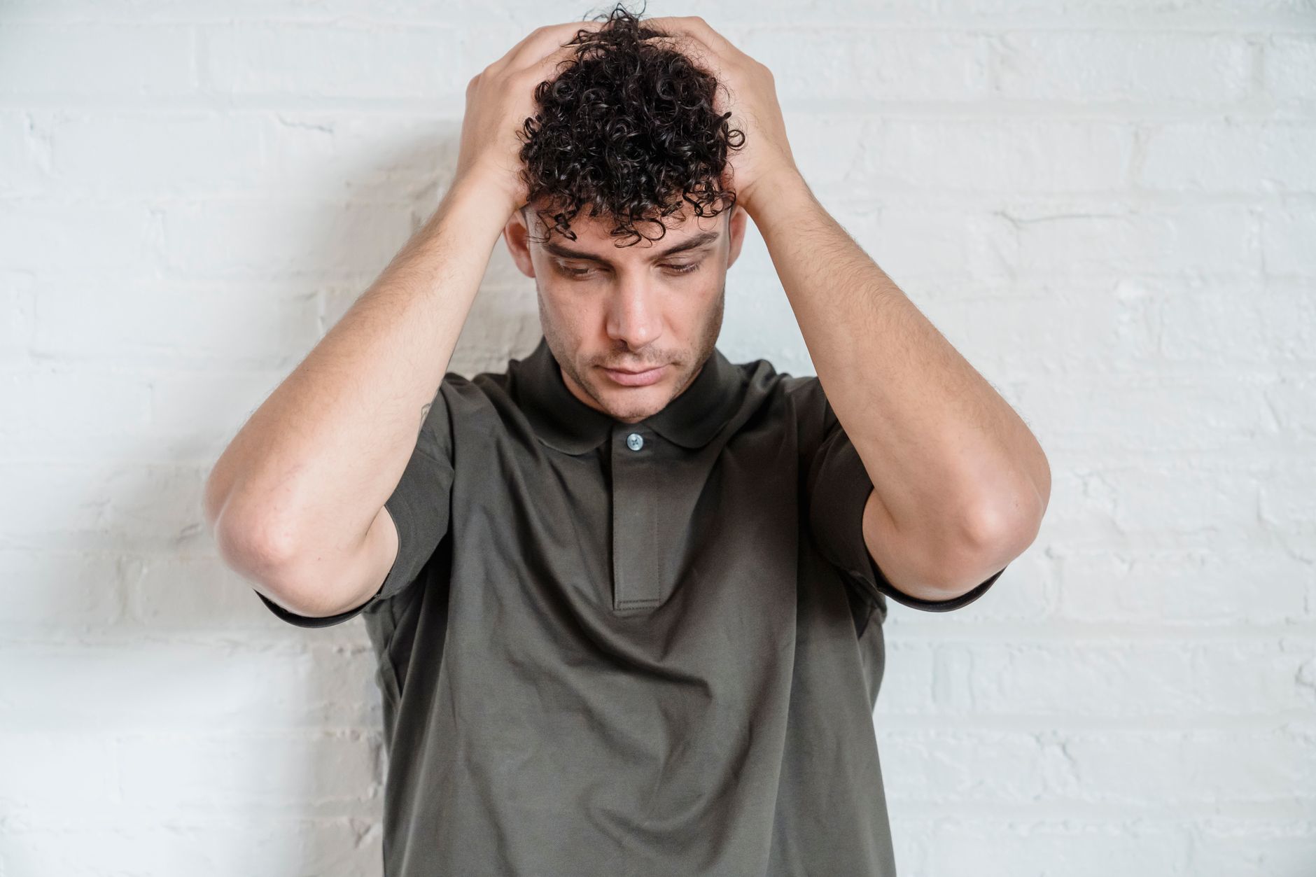 A person sitting down and holding their head, feeling lightheaded and dizzy