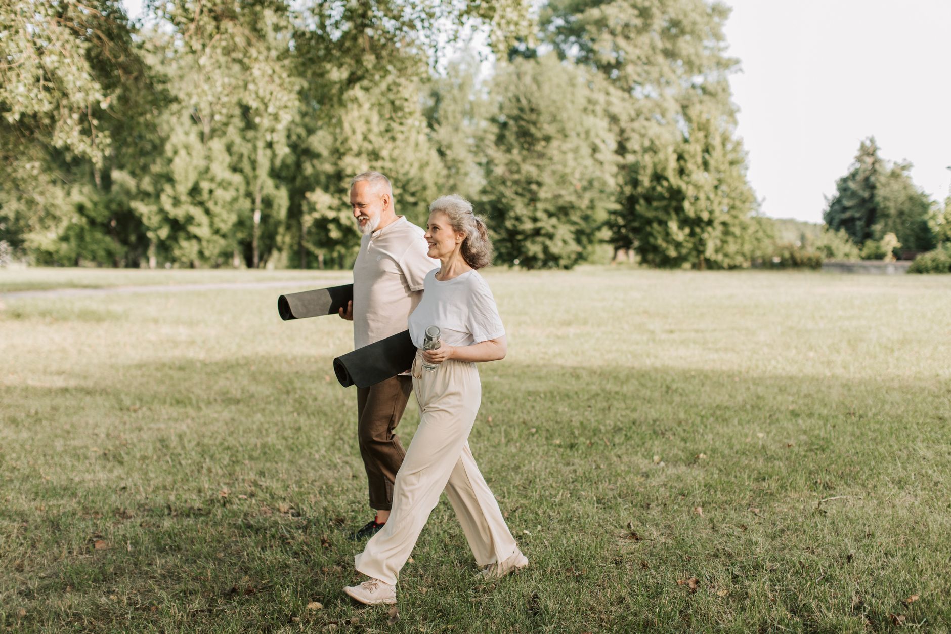 An older couple walking in a park as part of a heart-healthy lifestyle and cardiac rehabilitation