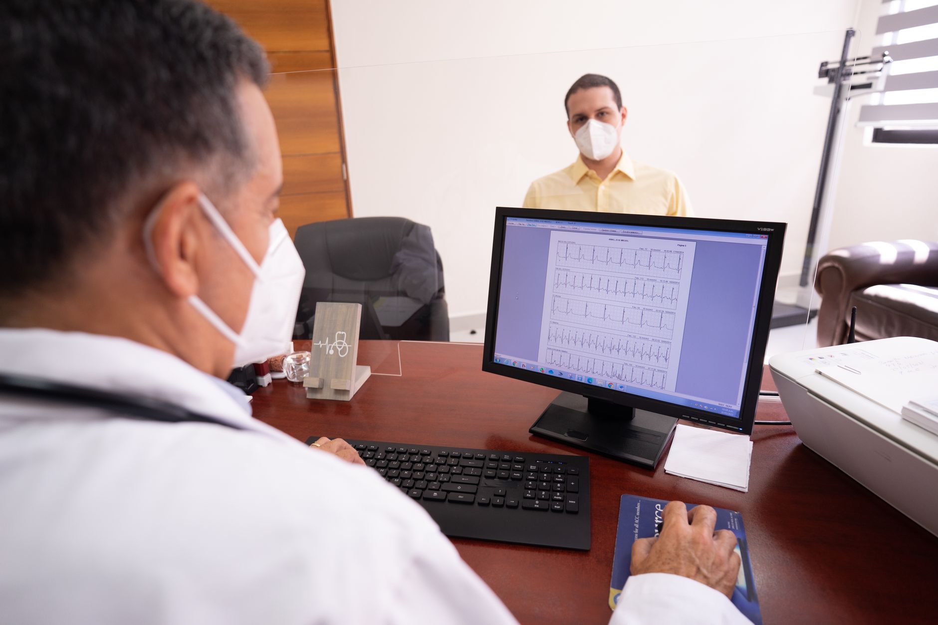 A doctor reviewing an ECG report with a young patient during a cardiac consultation