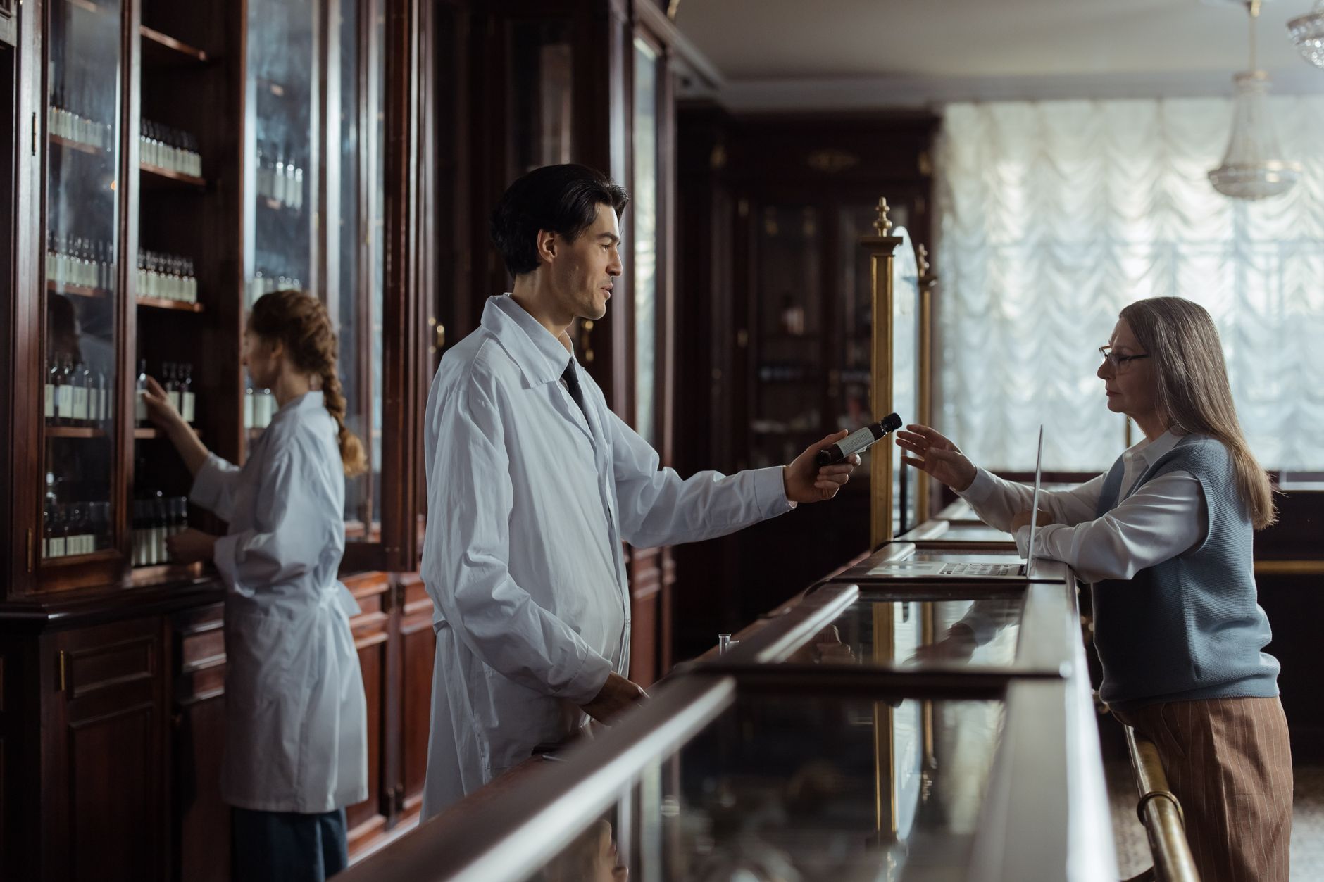 A pharmacist handing prescribed cholesterol medication to a patient