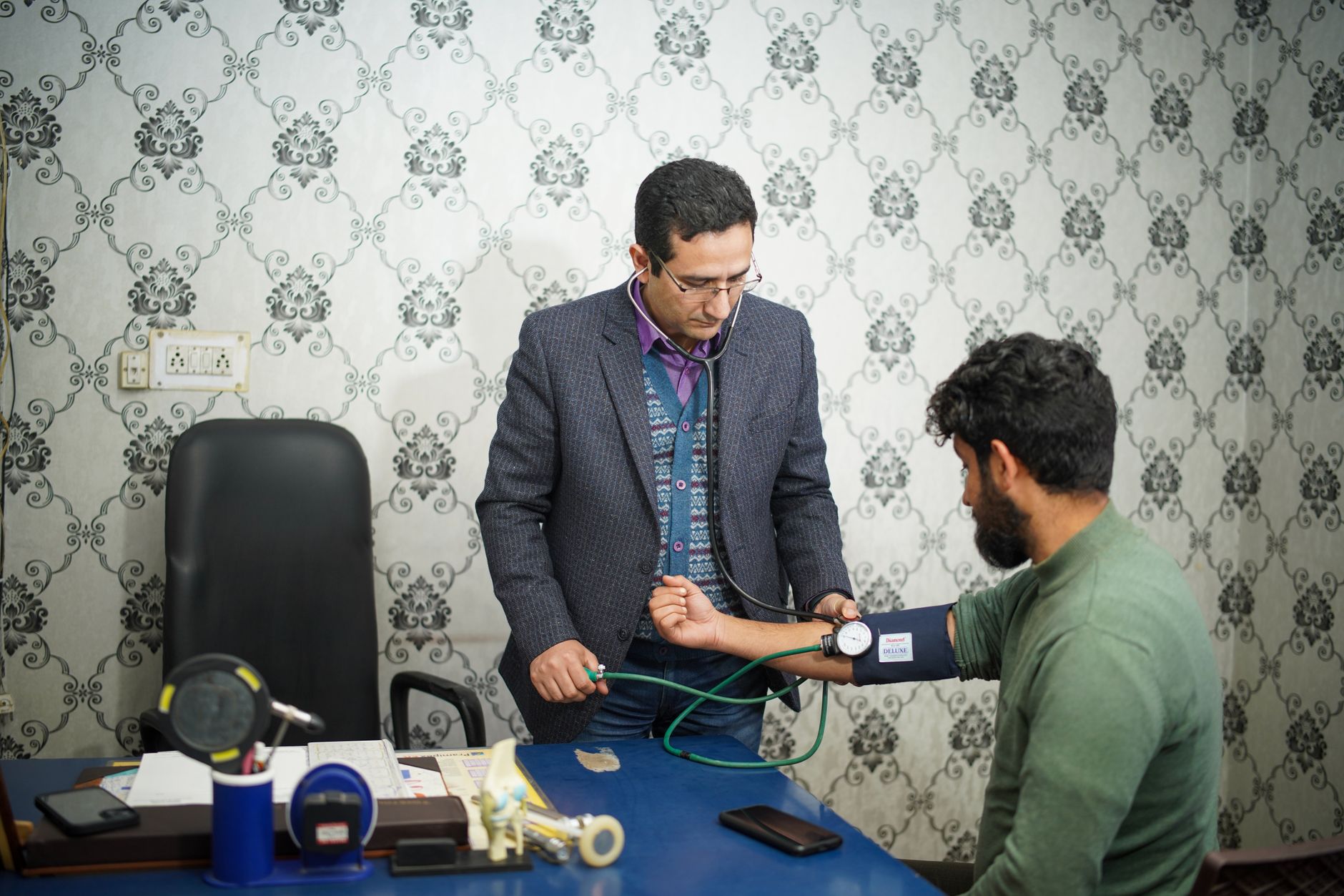 A doctor carefully examining a patient with a stethoscope during a cardiac consultation