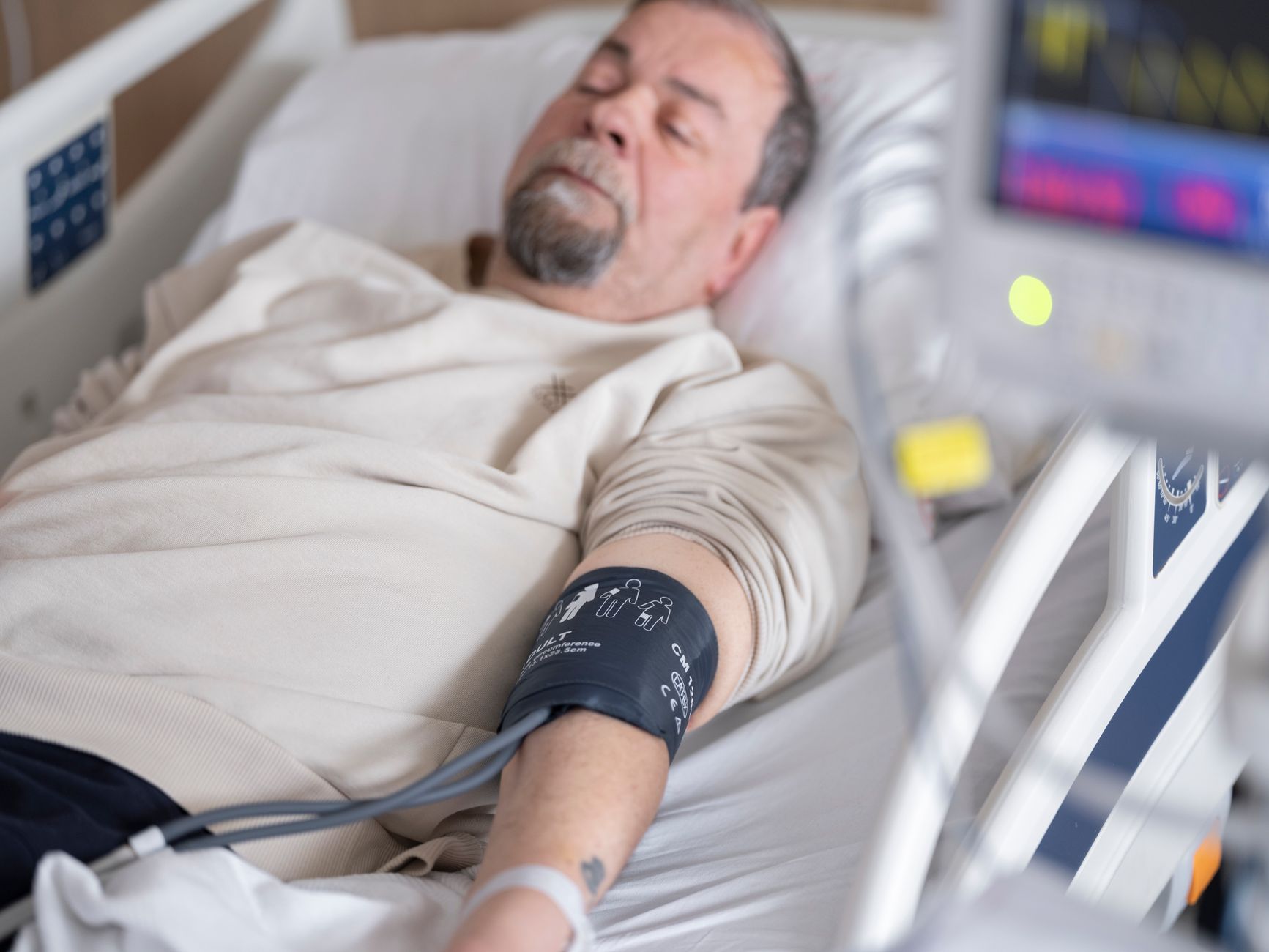 A patient resting comfortably in a hospital bed during cardiac care and recovery