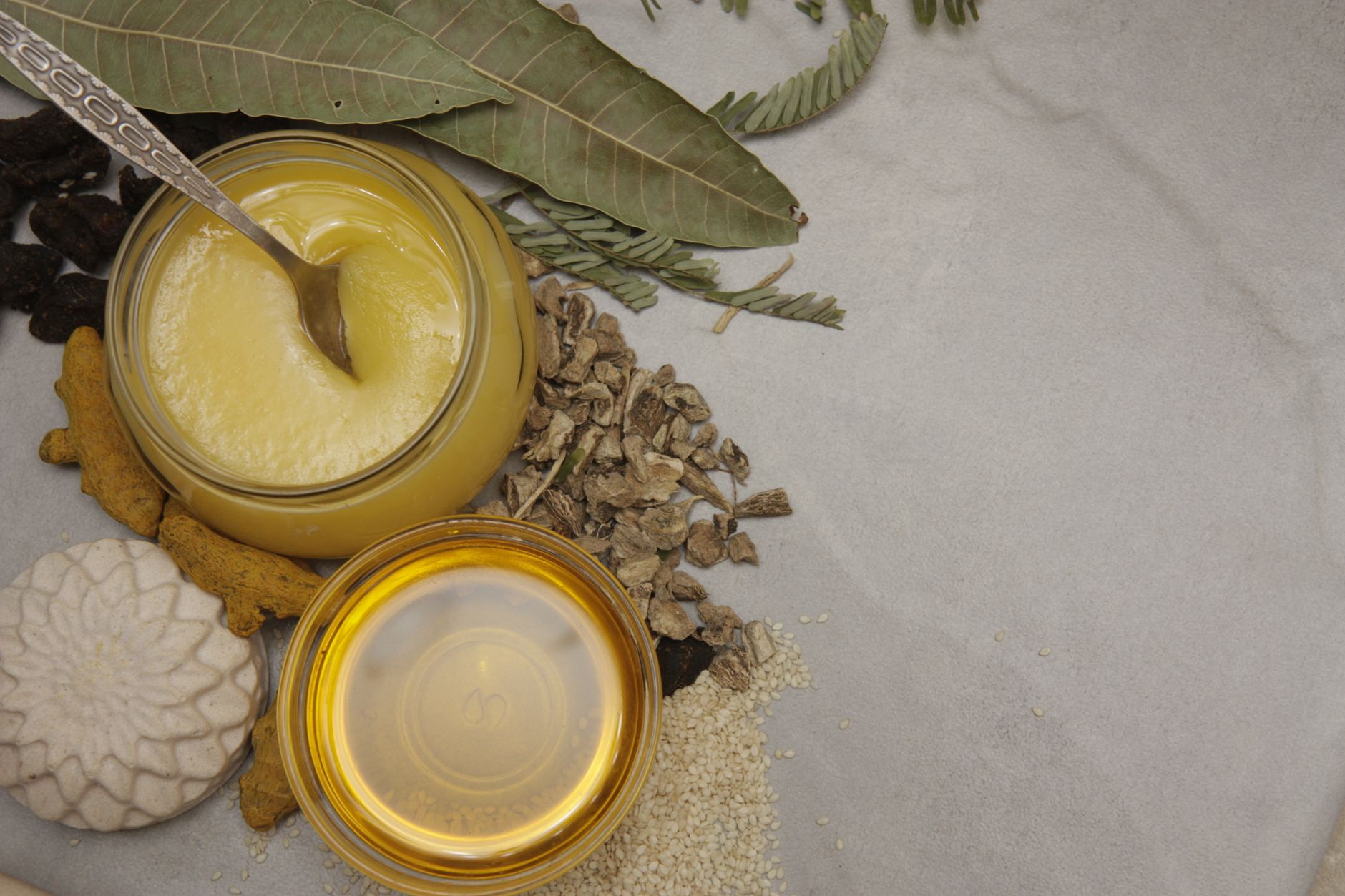 A bowl of golden clarified butter ghee with a wooden spoon