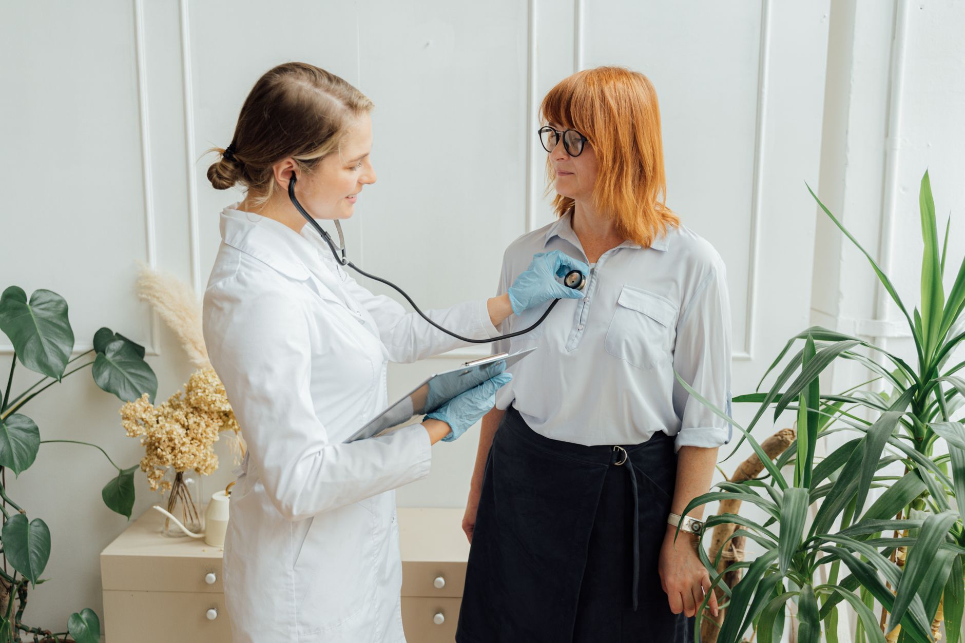 Cardiologist listening to a patient's heart with a stethoscope during a check-up