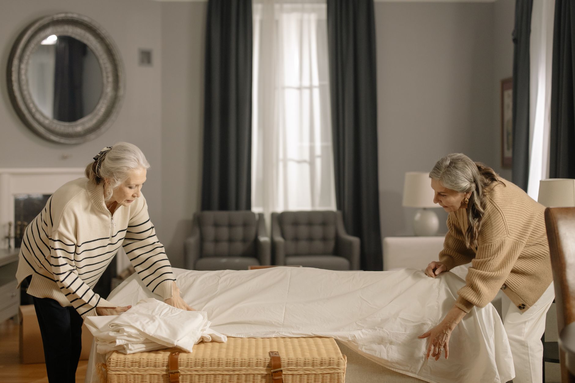 An elderly woman walking carefully indoors with the support of a family member