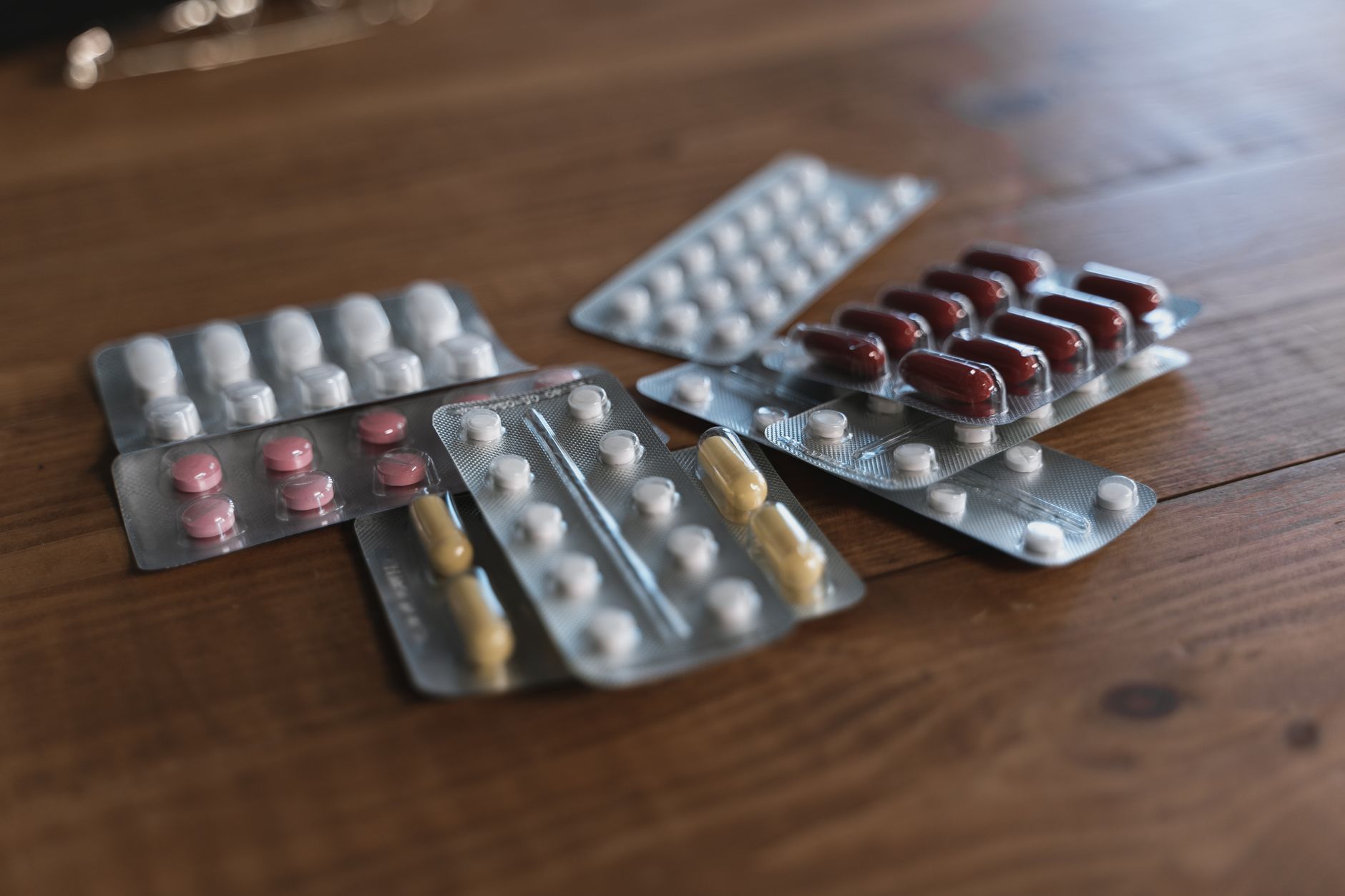 Several prescription medicine tablets and pills laid out on a table