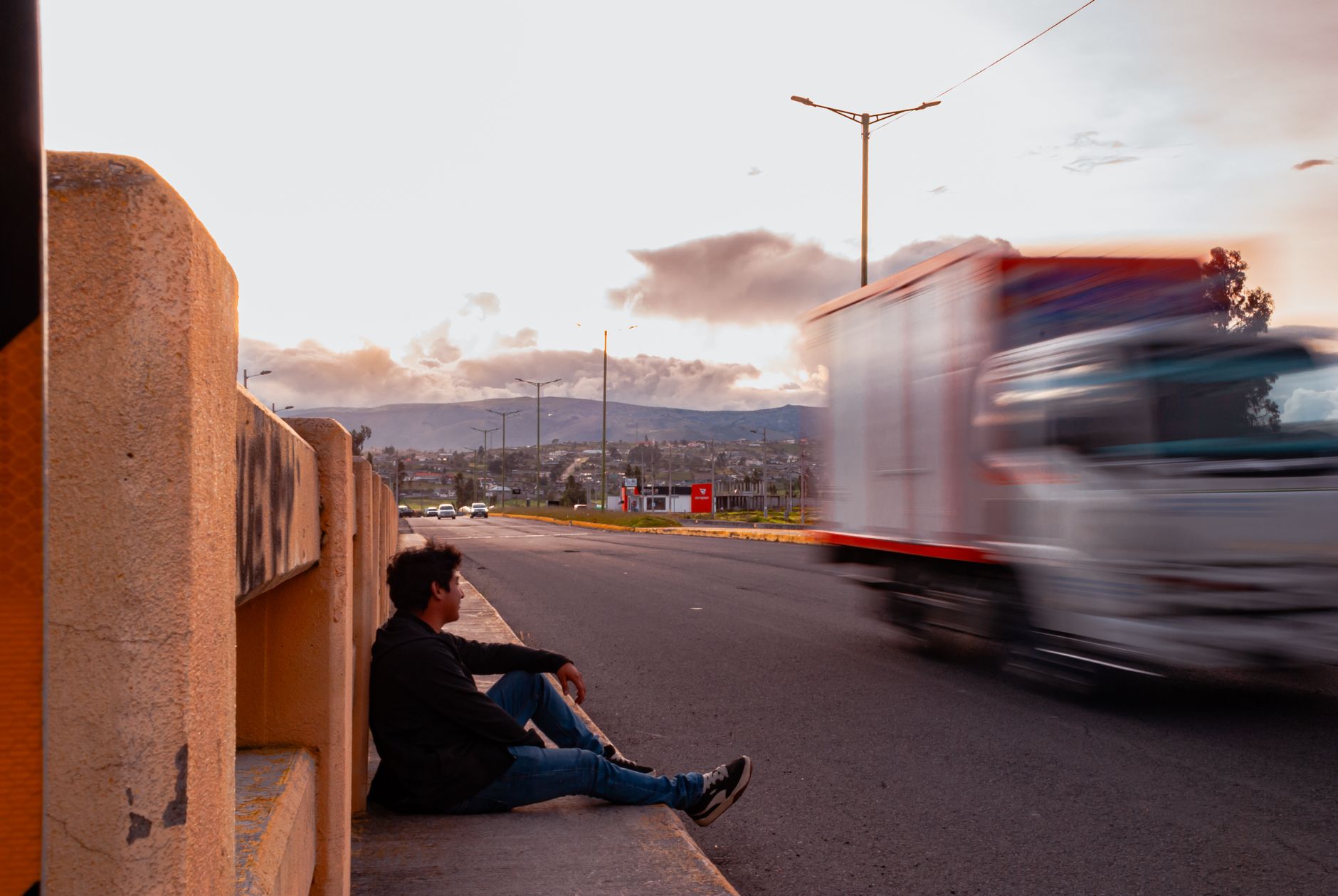 A man stretching his legs at a highway rest stop during a long journey
