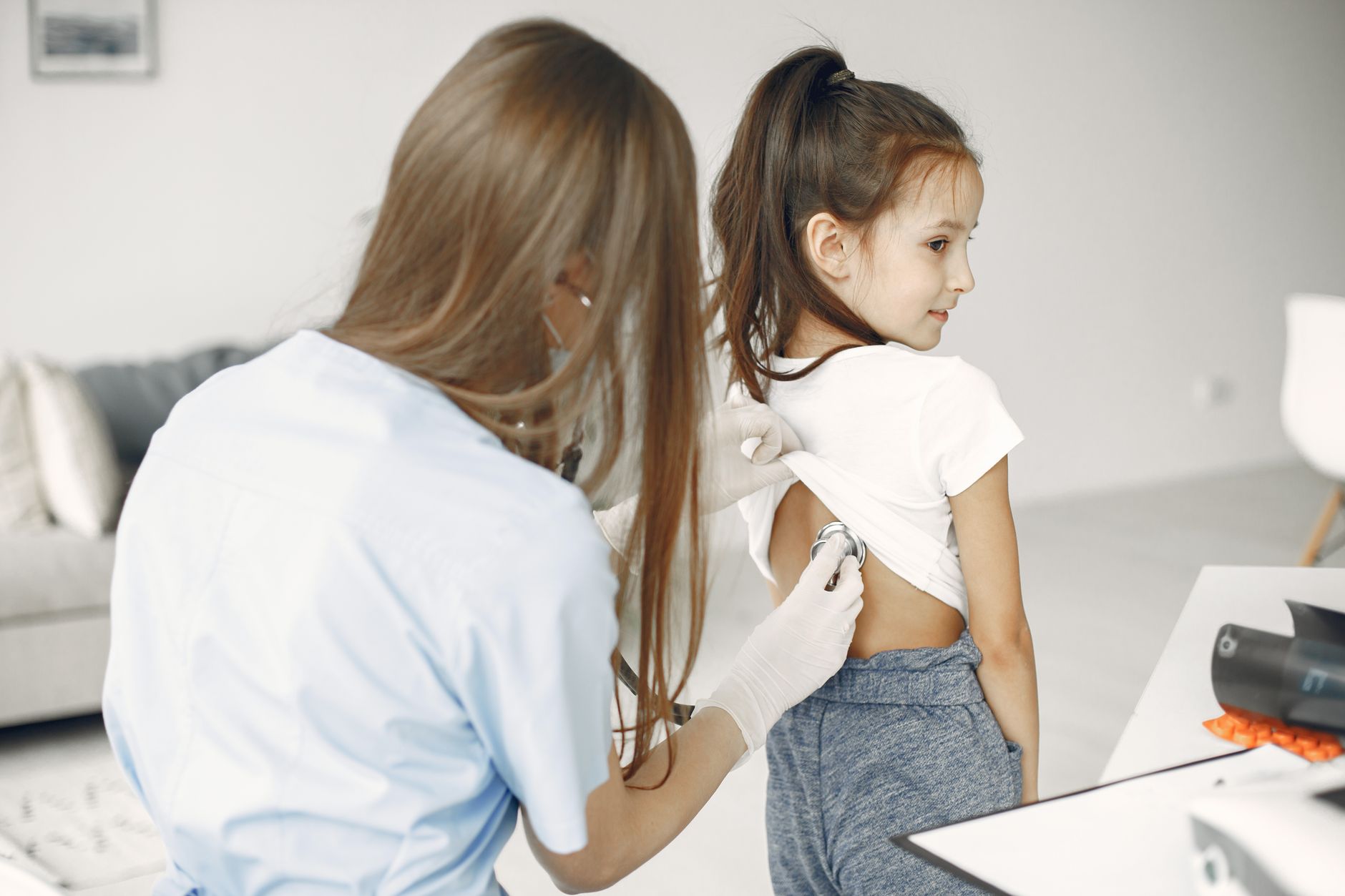A doctor listening to a young patient's heartbeat with a stethoscope during a cardiac check-up