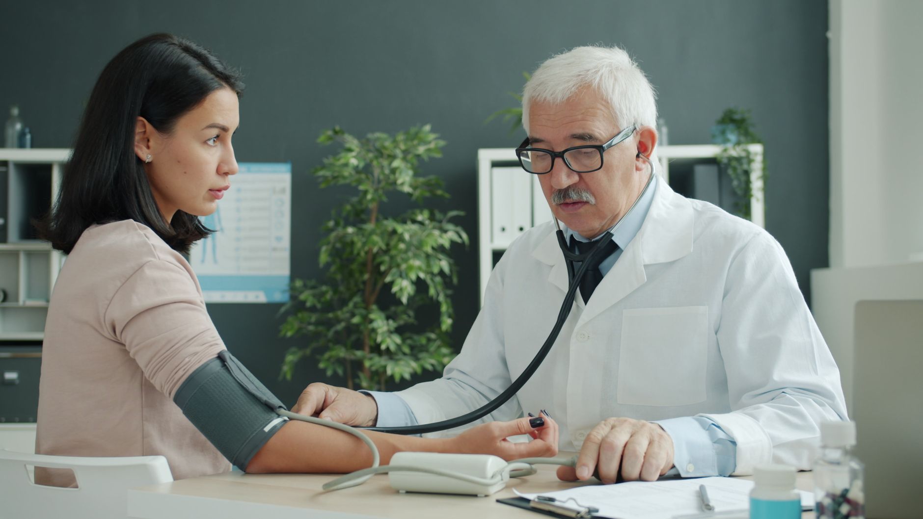 A doctor checking a patient's blood pressure during a routine cardiac check-up