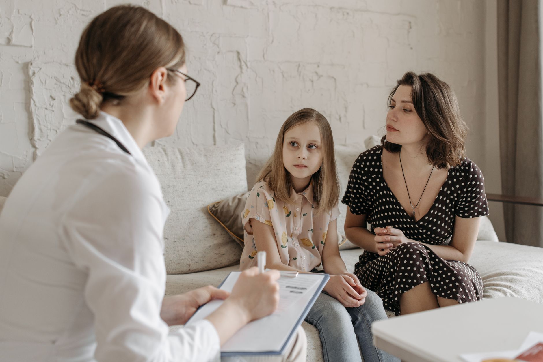 A cardiologist discussing a child's heart health with concerned parents in a clinic
