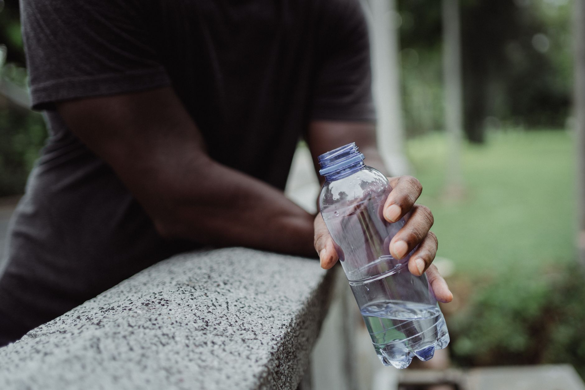 Person drinking water to stay hydrated during outdoor activity