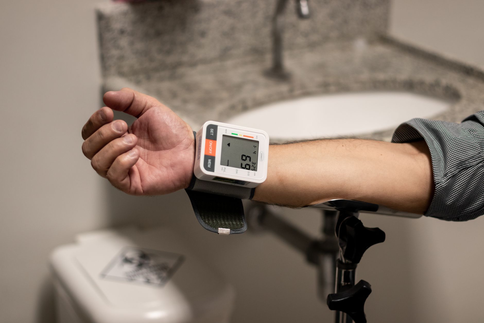 Close-up of a digital blood pressure monitor showing systolic and diastolic readings