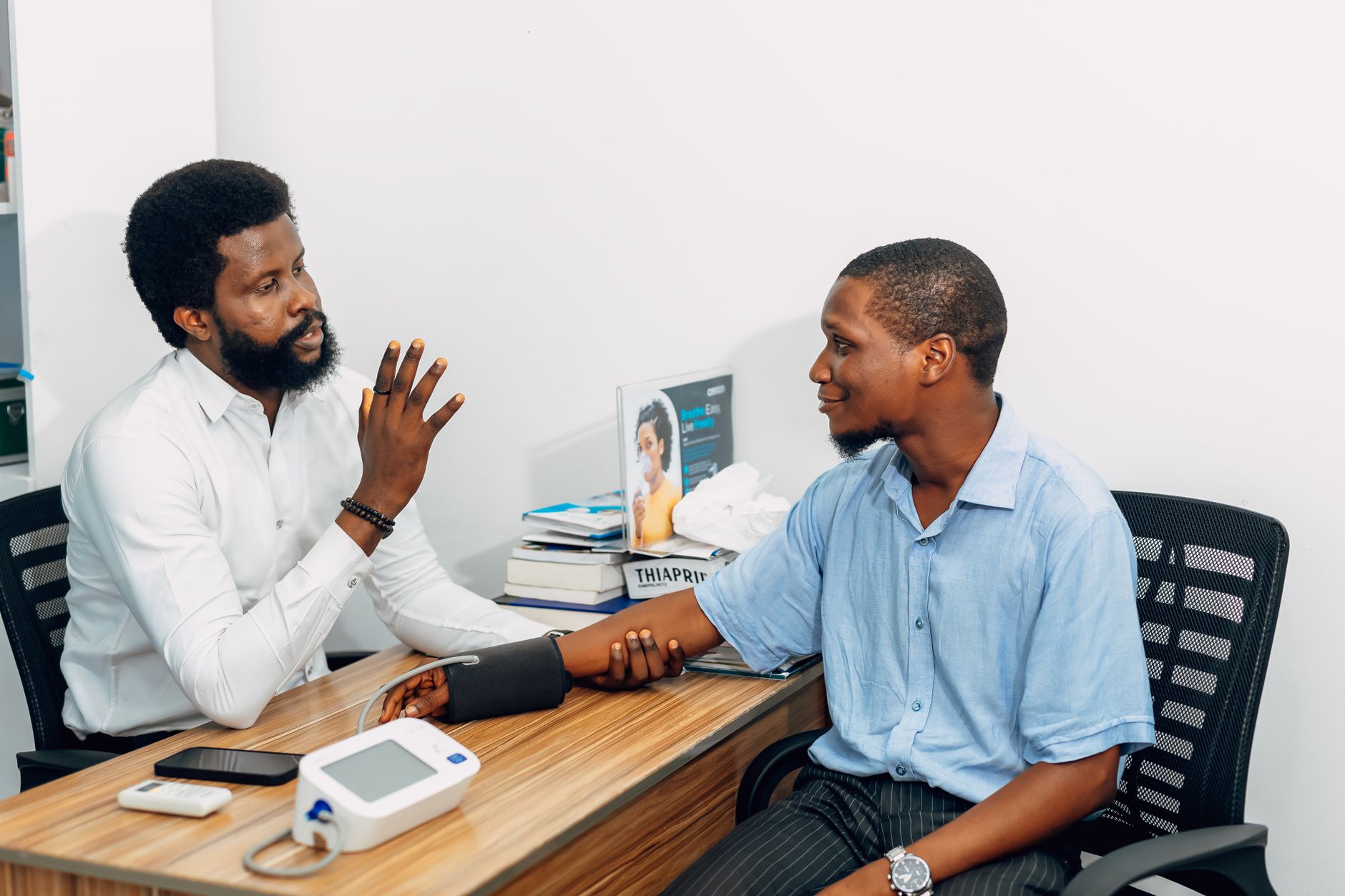 Doctor explaining a blood pressure chart to a patient during a consultation