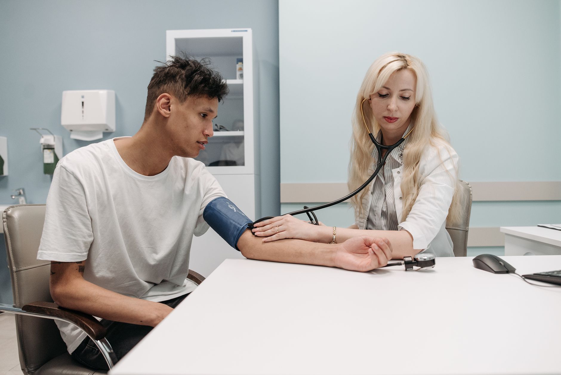 A doctor measuring the blood pressure of an older patient in a clinic setting