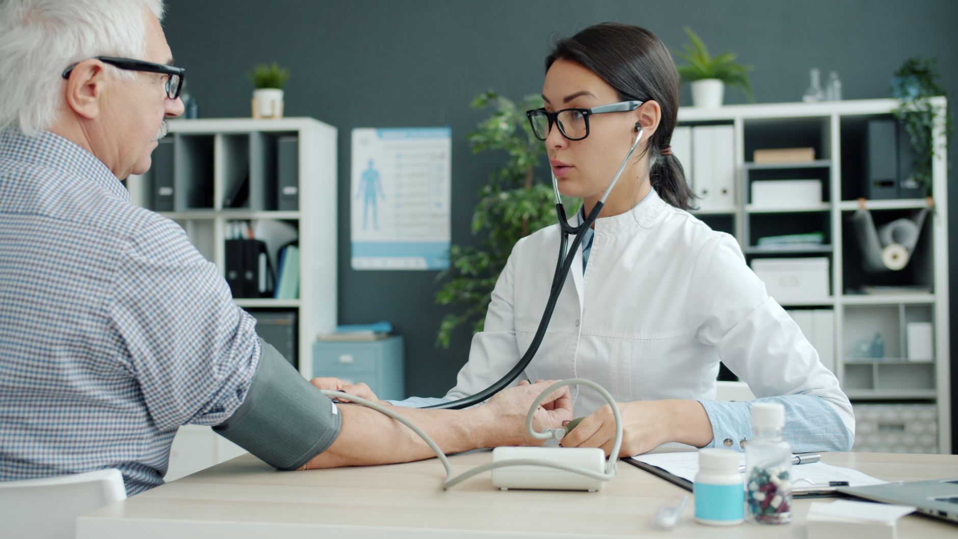 A doctor measuring an elderly patient's blood pressure during a routine check-up