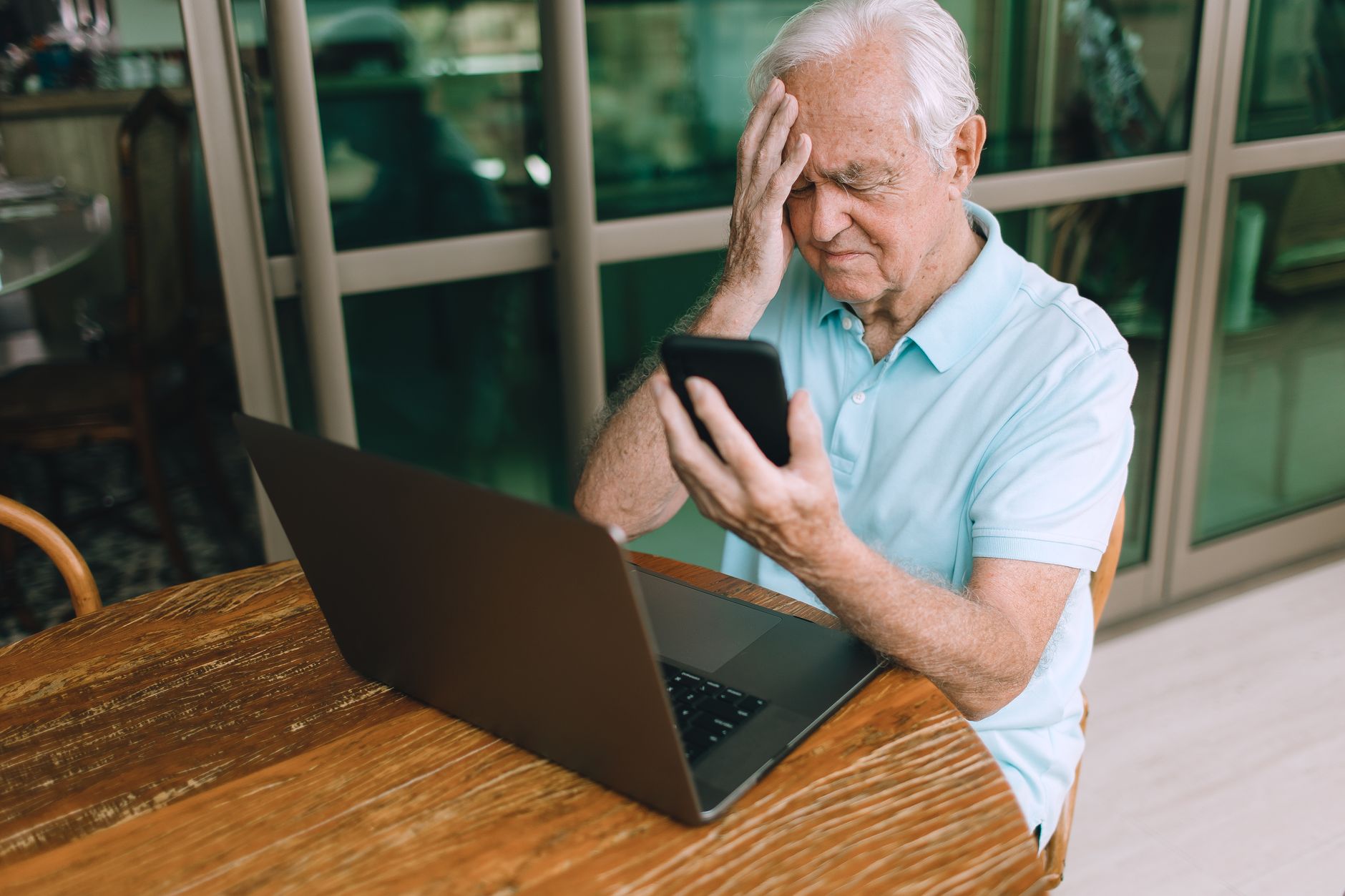 An older person feeling dizzy and sitting down, a common symptom of low blood pressure
