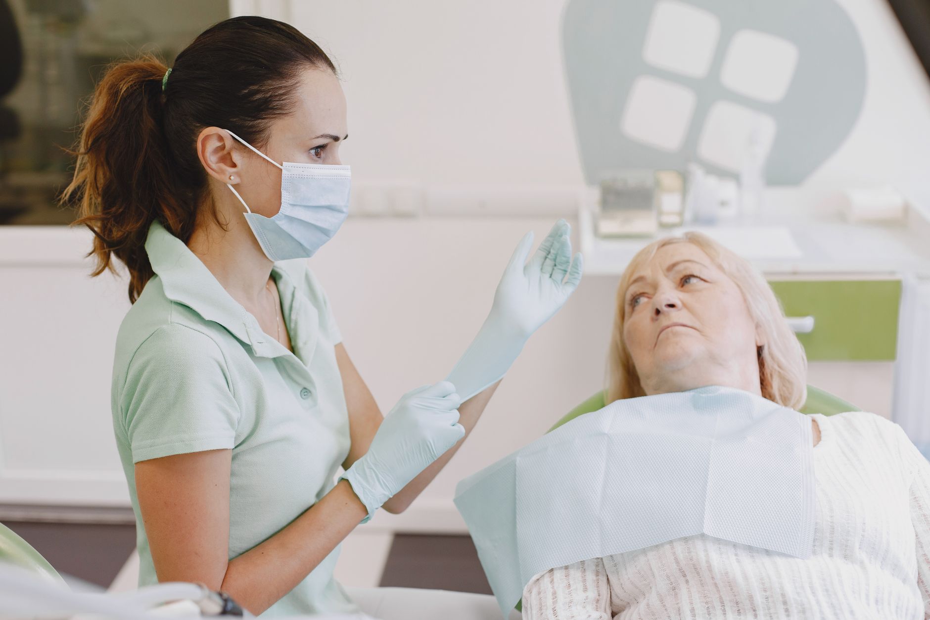 Senior woman discussing symptoms with a female doctor in a clinic consultation