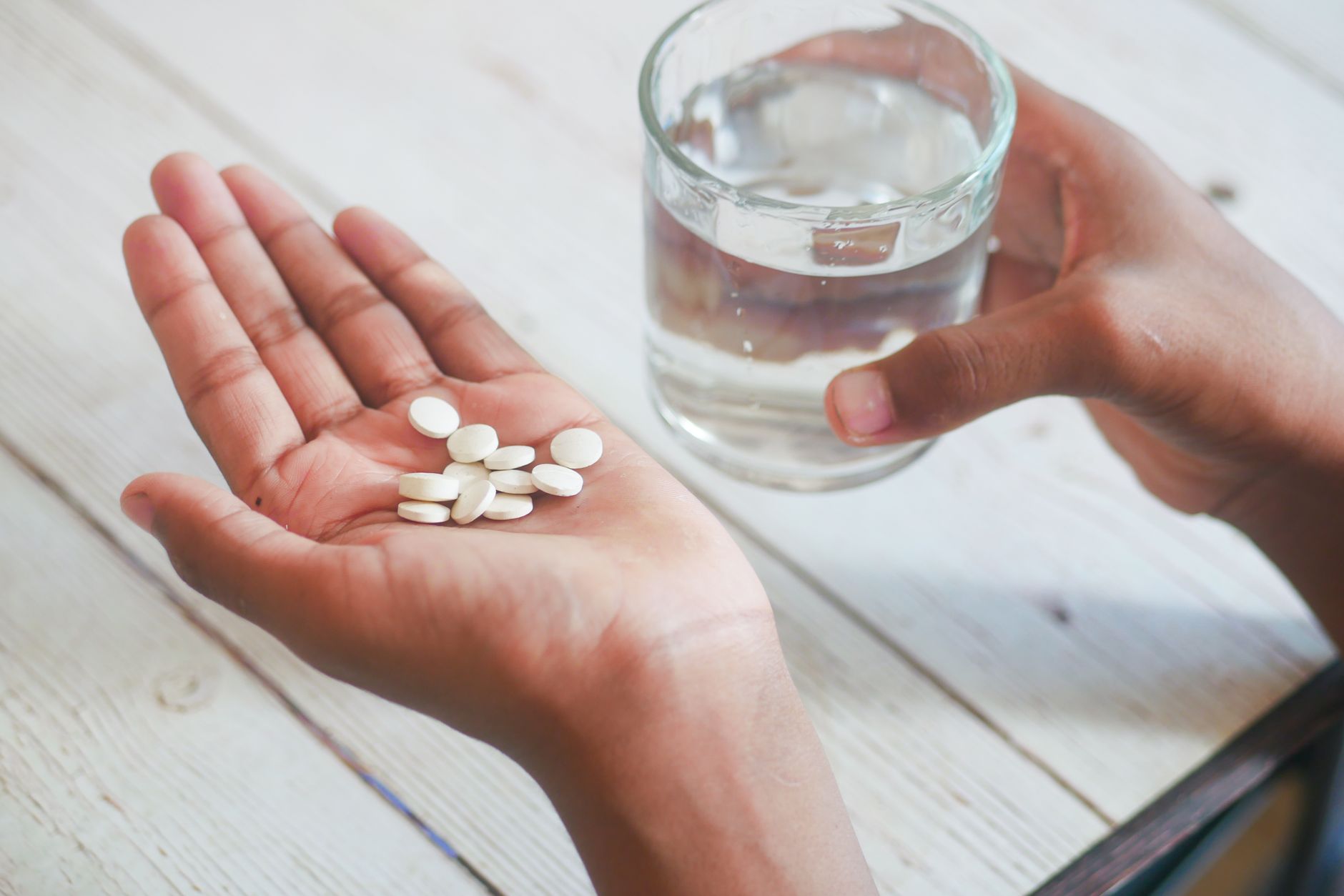 A person carefully reading a medicine label before taking tablets