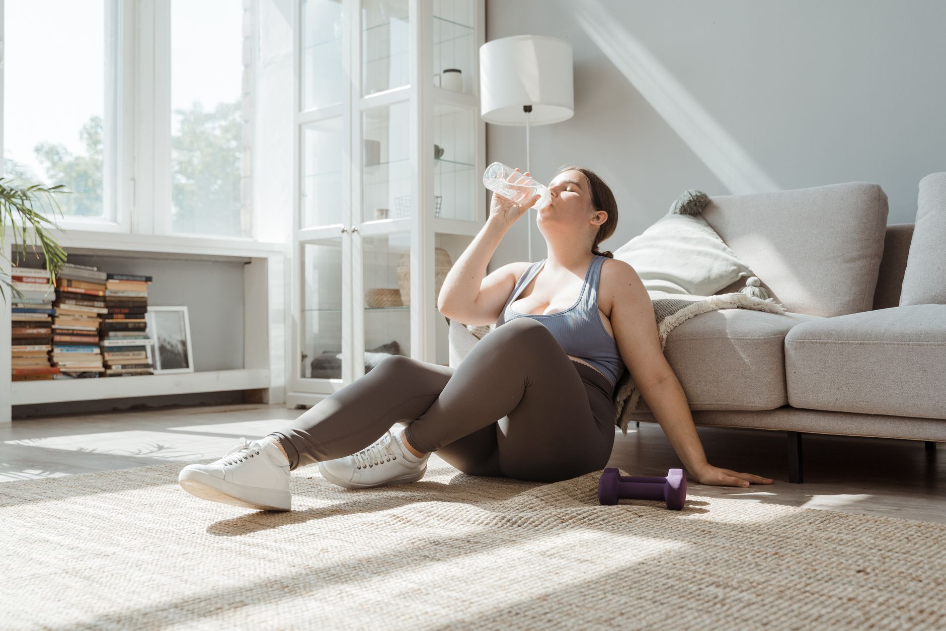 A woman resting comfortably and staying hydrated to manage symptoms