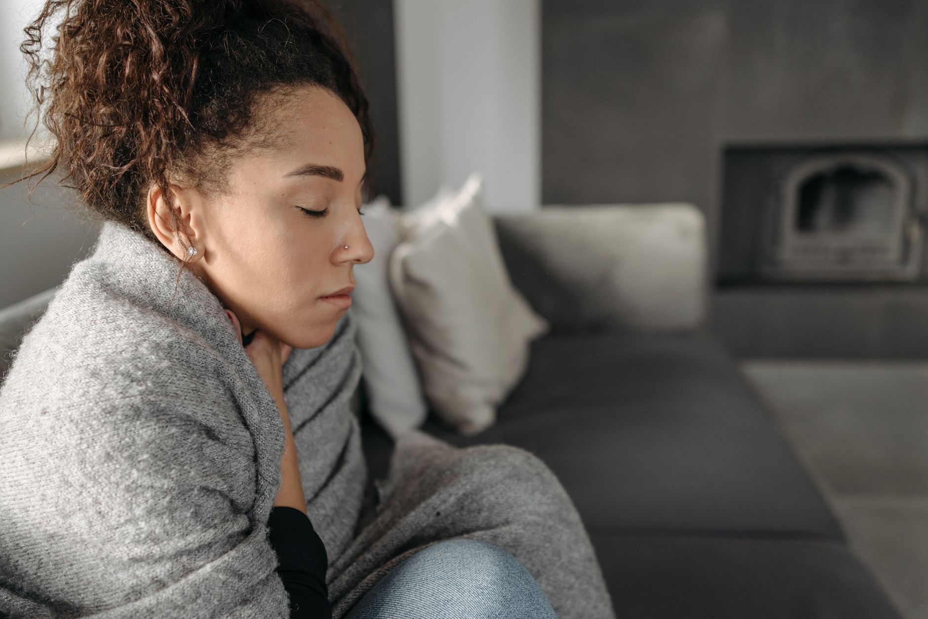 A young woman resting on a sofa, representing the fatigue and discomfort common in POTS syndrome