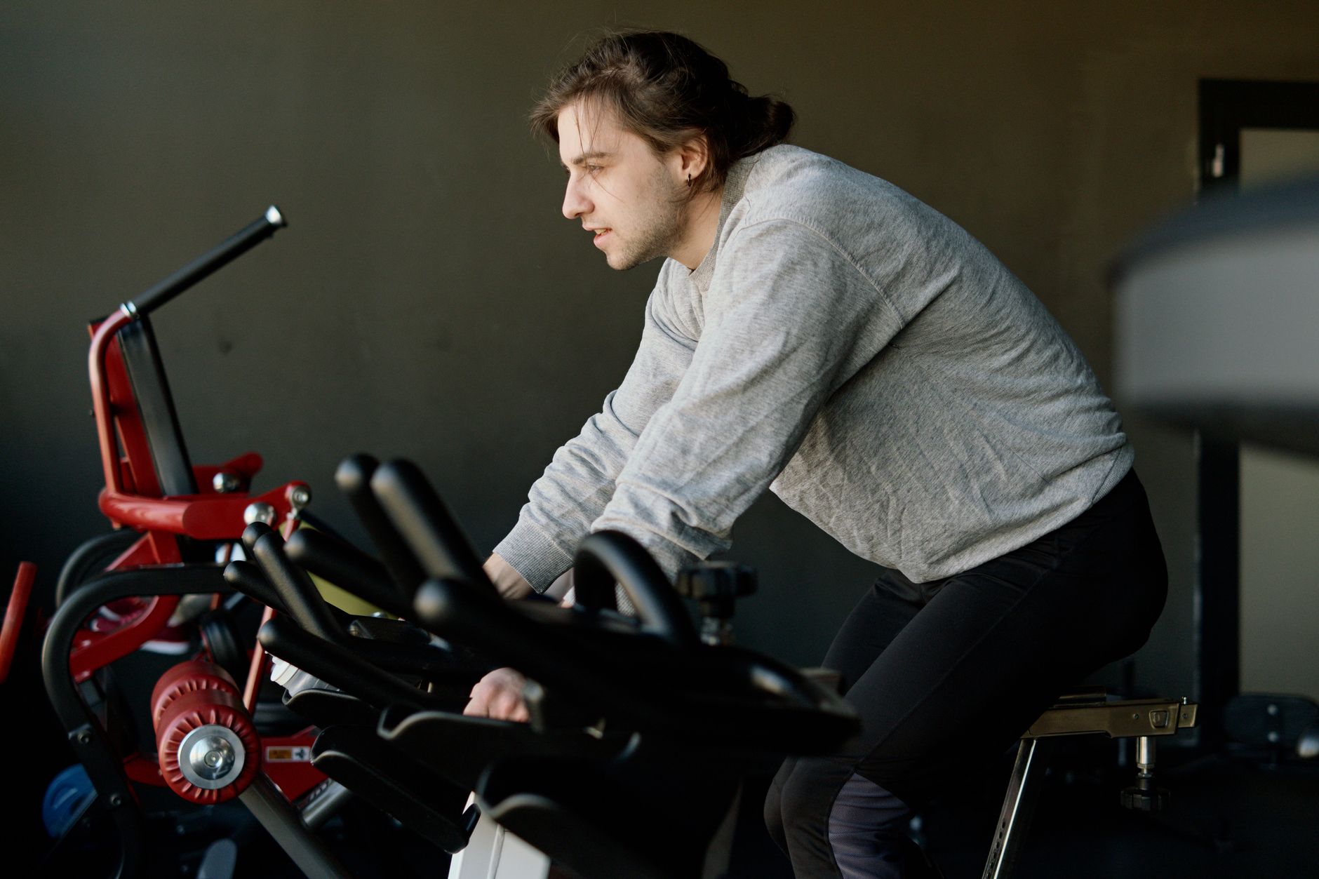 A person exercising on a stationary recumbent bike, a recommended low-impact exercise for POTS management