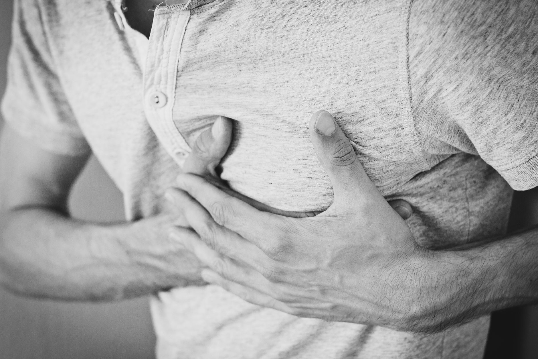 Person experiencing chest discomfort — a common warning sign of a cardiac emergency