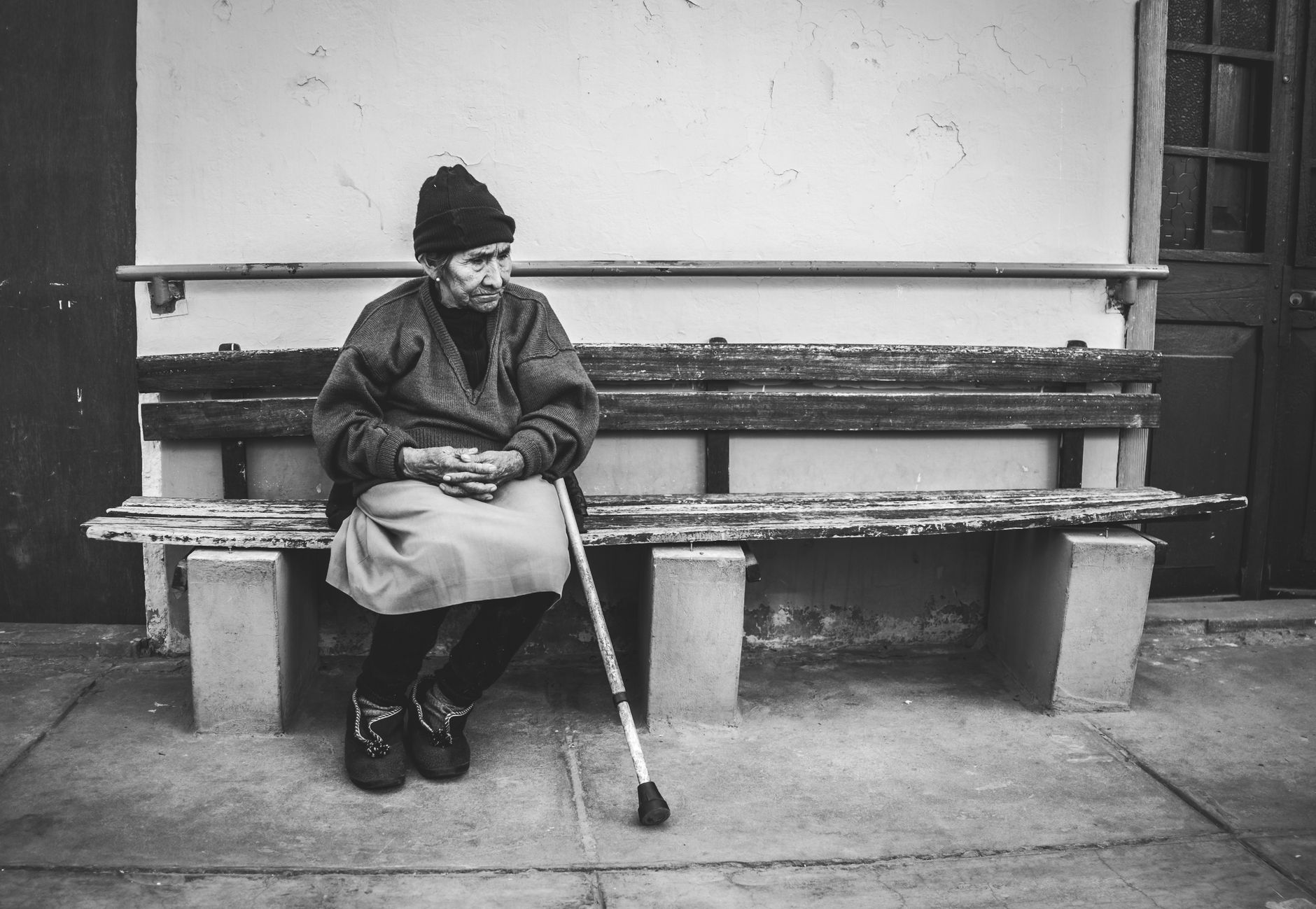 An older person resting on a bench, experiencing shortness of breath