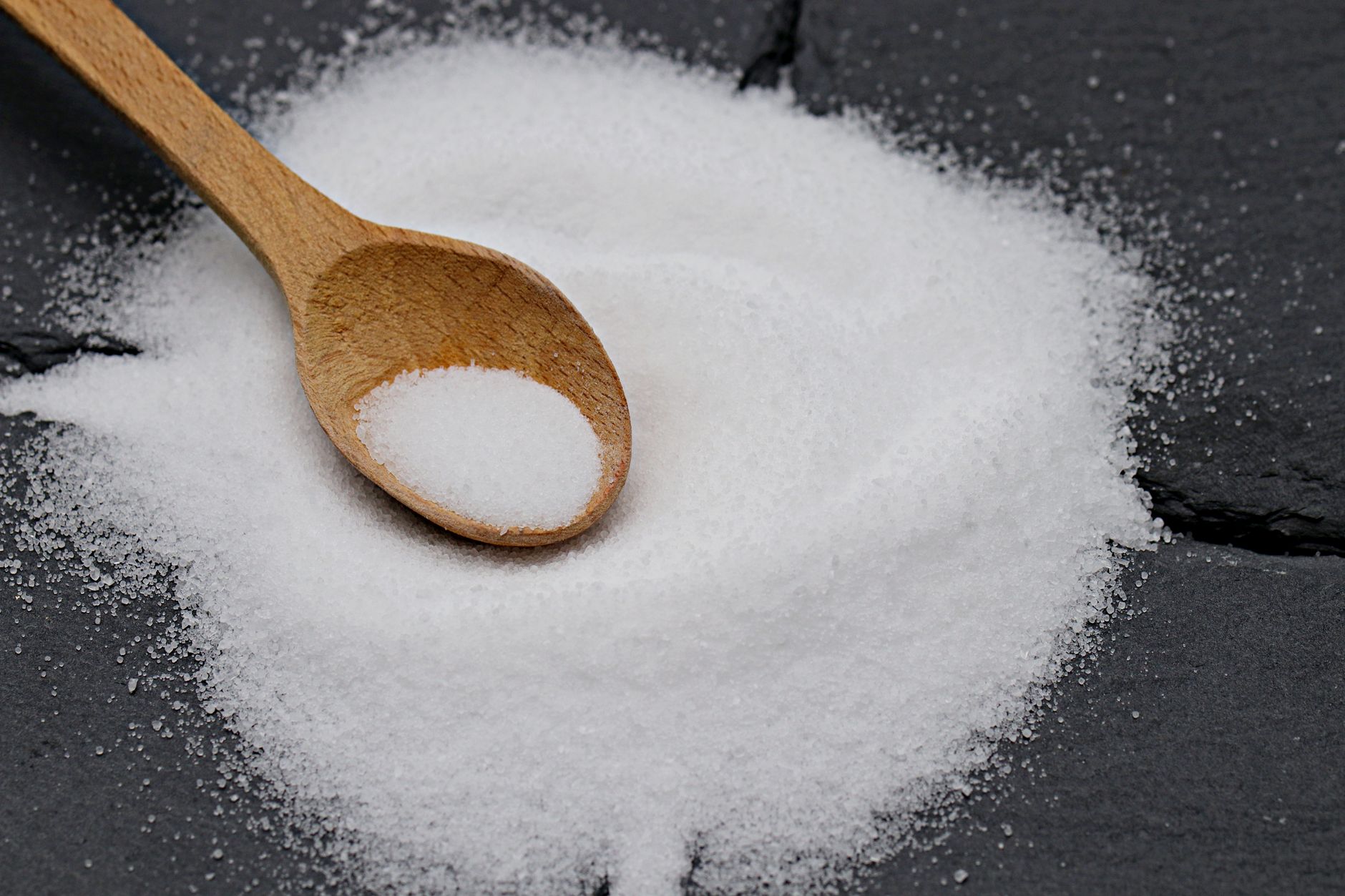 Teaspoons of salt and sugar side by side, representing daily dietary limits