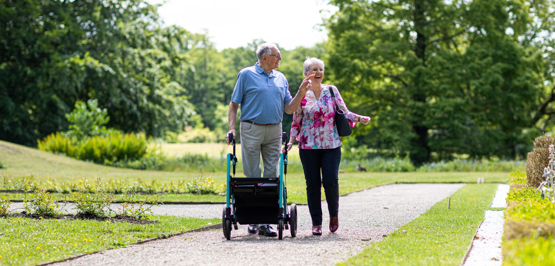 A senior couple walking together in a park, symbolising gradual return to activity after a heart event