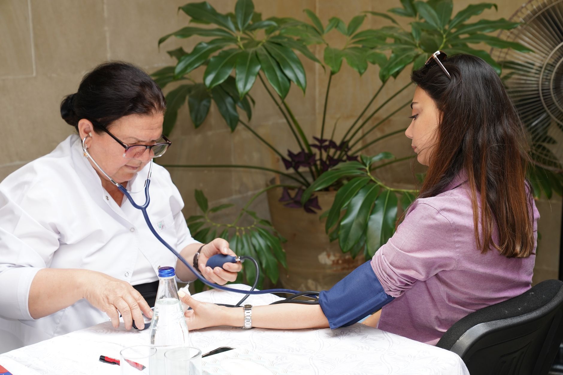 A doctor checking a patient's blood pressure as part of a cardiac risk assessment