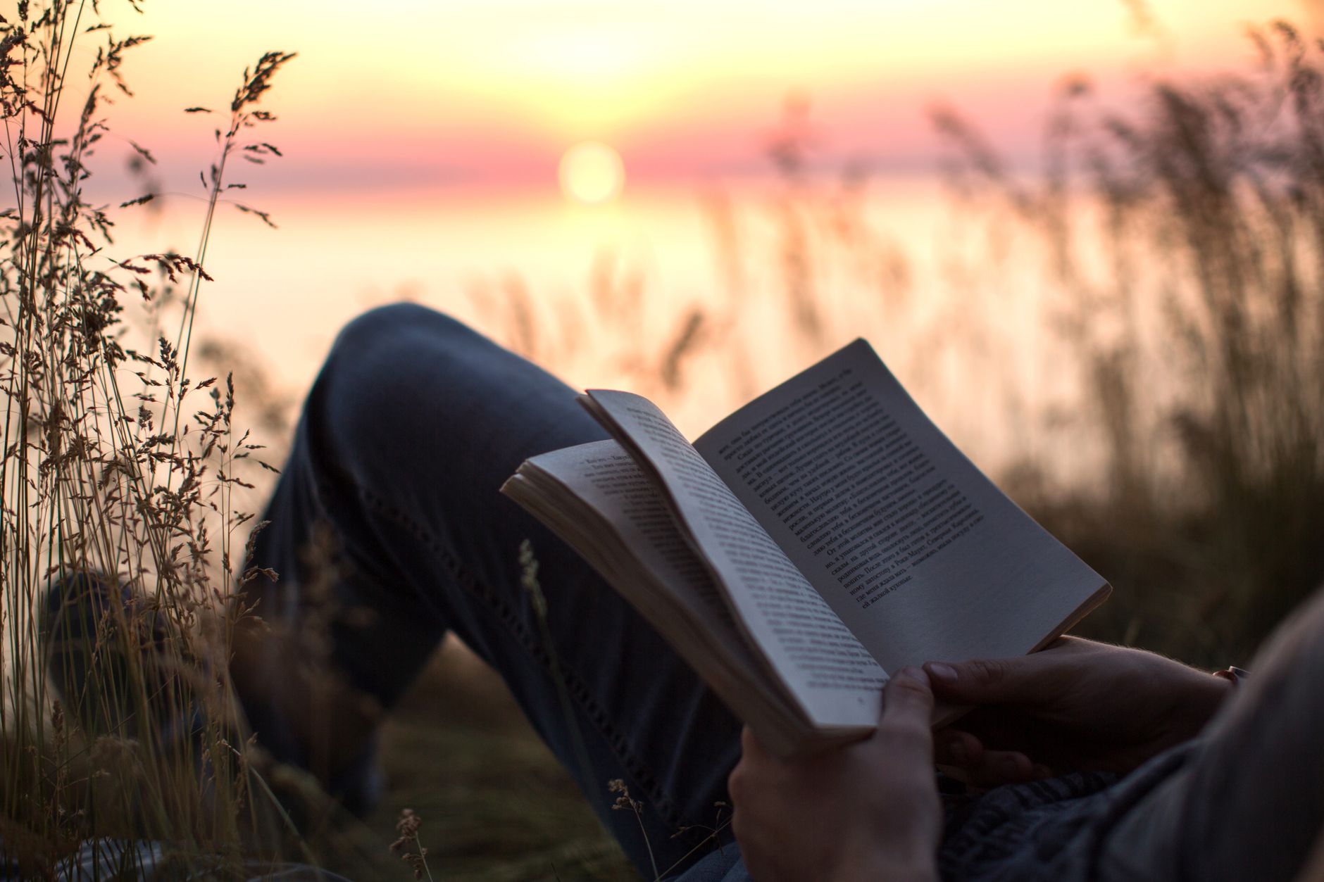 Person relaxing with a book in the evening as part of a calming bedtime routine