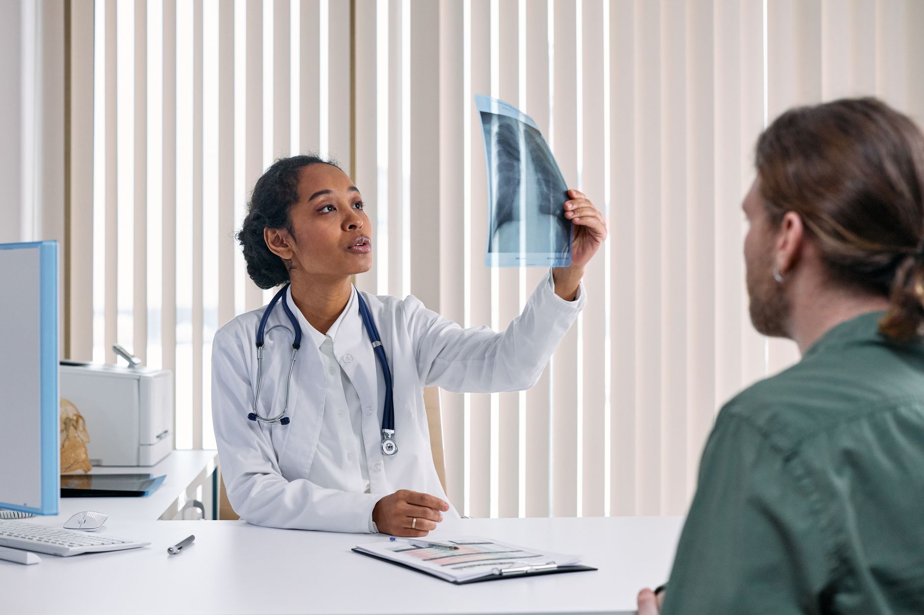 Cardiologist explaining a heart diagram to a female patient in a clinic