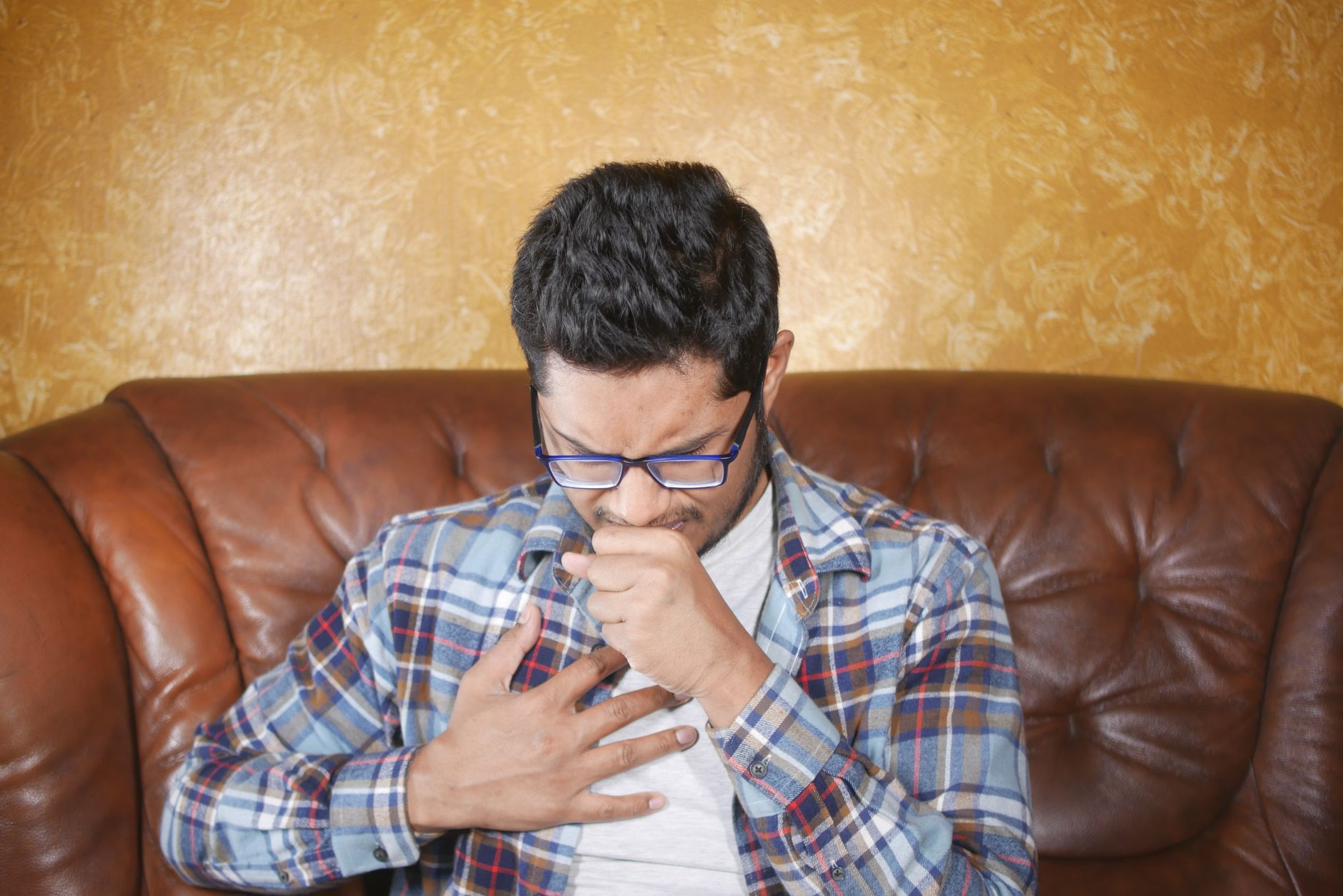 A person sitting calmly and placing a hand on their chest, representing heart palpitation awareness