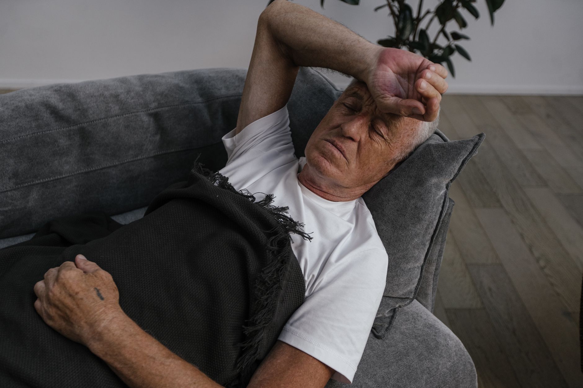 Senior woman resting on a sofa, looking fatigued — a common symptom of hypothyroidism