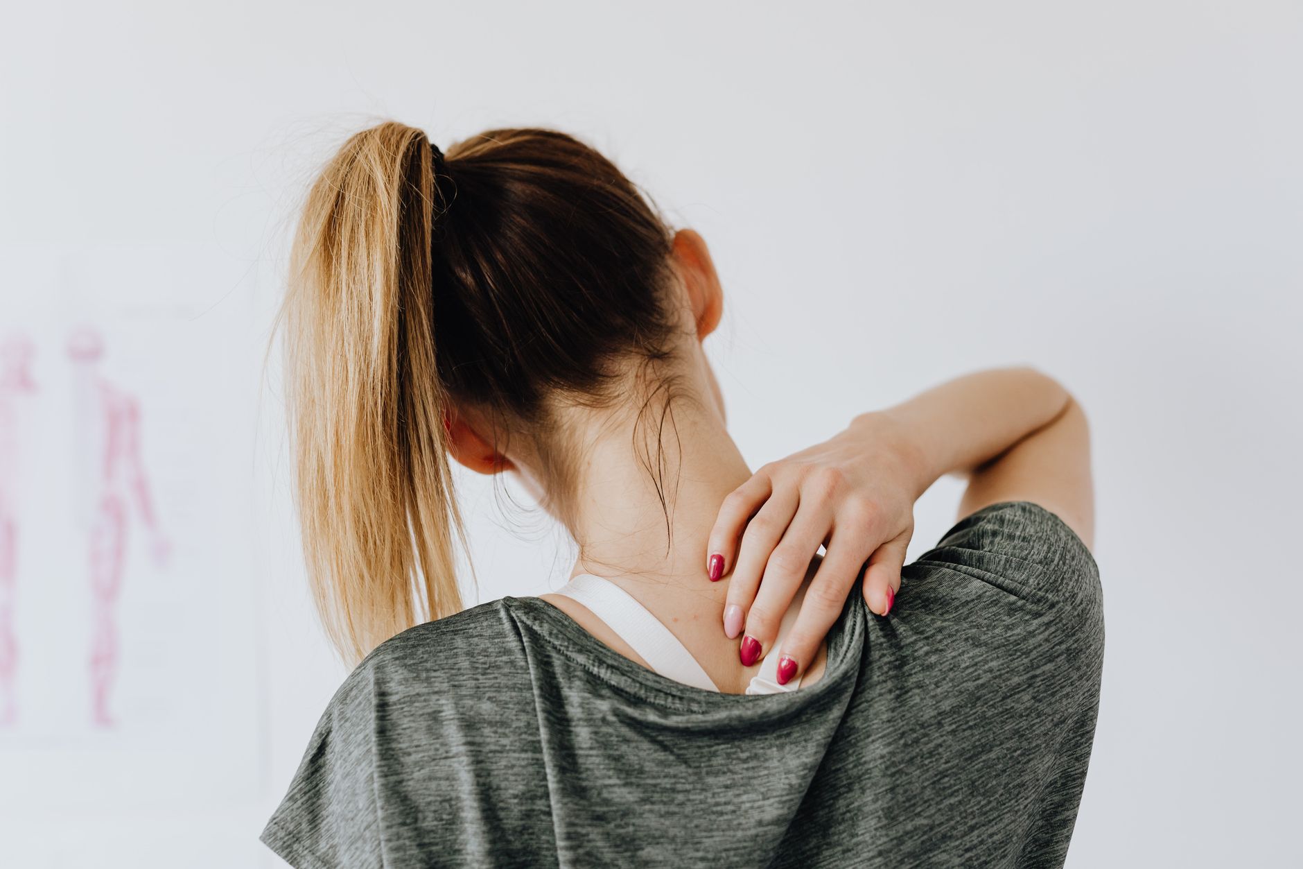 A woman experiencing neck and shoulder discomfort, a potential atypical heart symptom